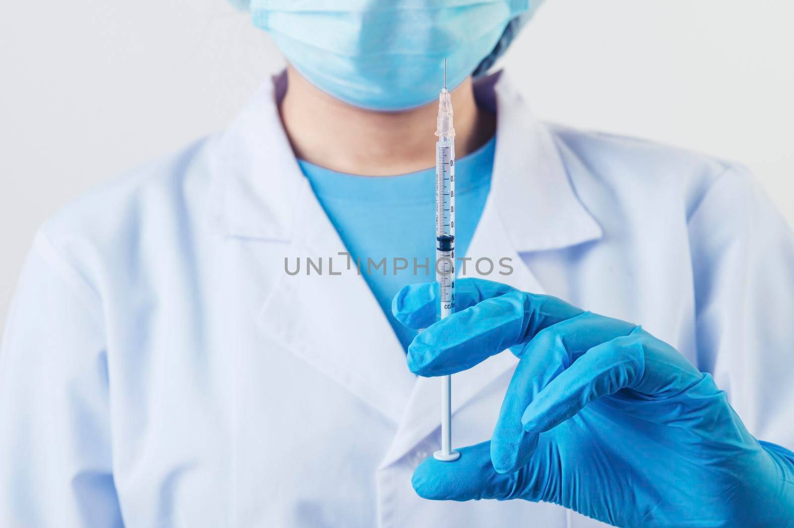 Closeup syringe injection needle of covid-19 vaccine in professional scientist or doctor hand in lab for treatment with mask gloves lab coat on white background. Health business industry concept.