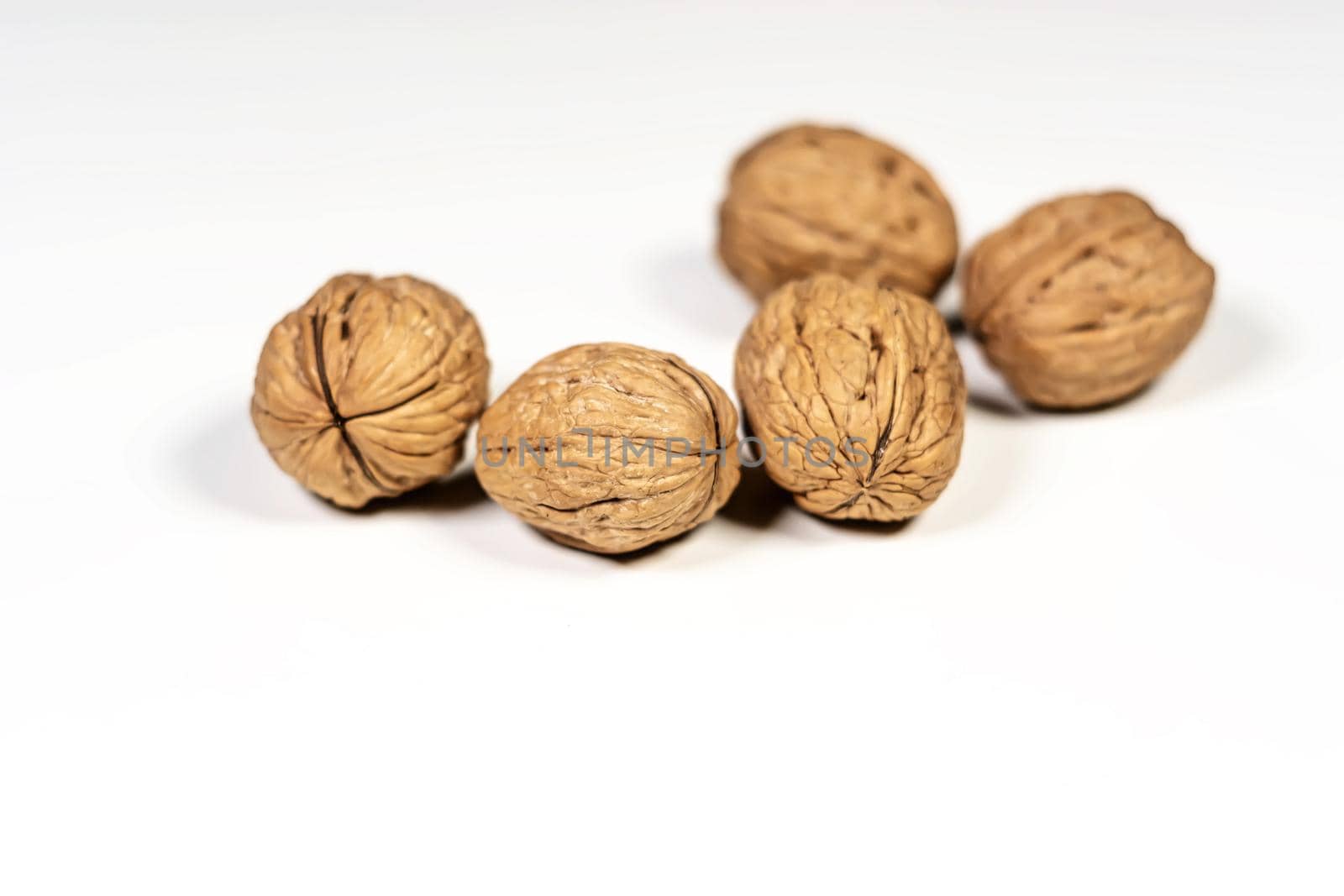 A group of five walnuts isolated on a white background. Healthy lifestyle and food