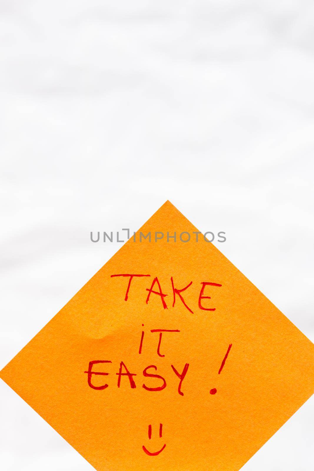 Take it easy handwriting text close up isolated on orange paper with copy space.