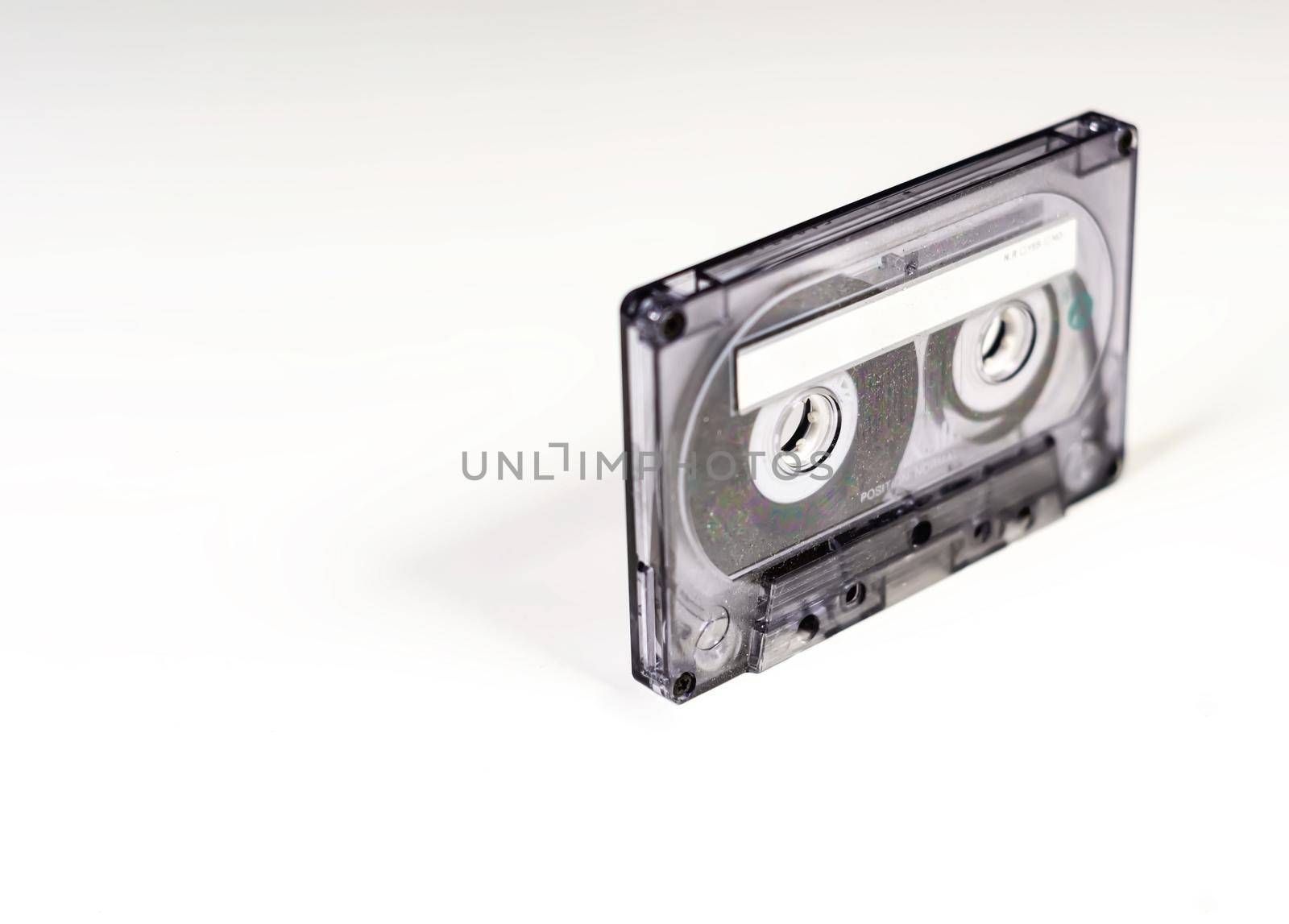 Transparent 90 minute audio cassette with blank adhesive label. Side A of the cassette. Magnetic tape and audio reproduction from the 70s and 80s. Vintage object
