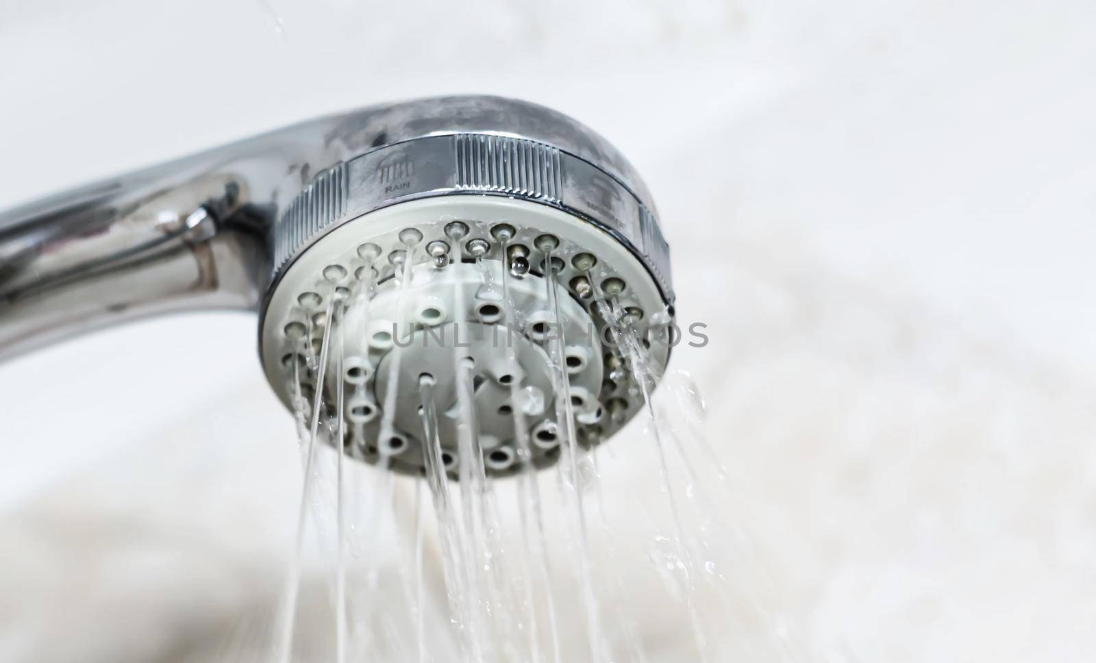 Interior of a shower with water flowing from the shower head. Droplets and moisture. Walls with decorated tiles. by rarrarorro