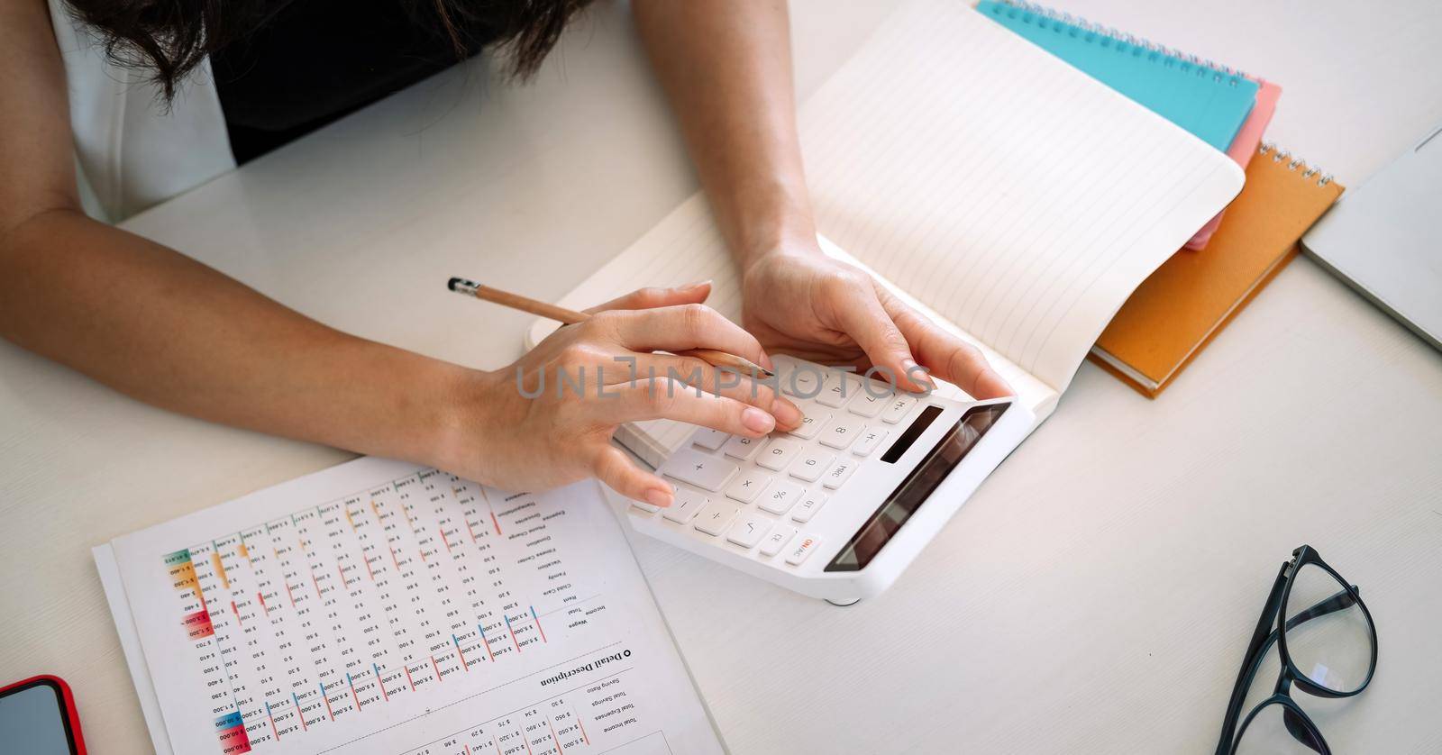 Top view, Business woman working financial accounting with calculator and fianancial data.