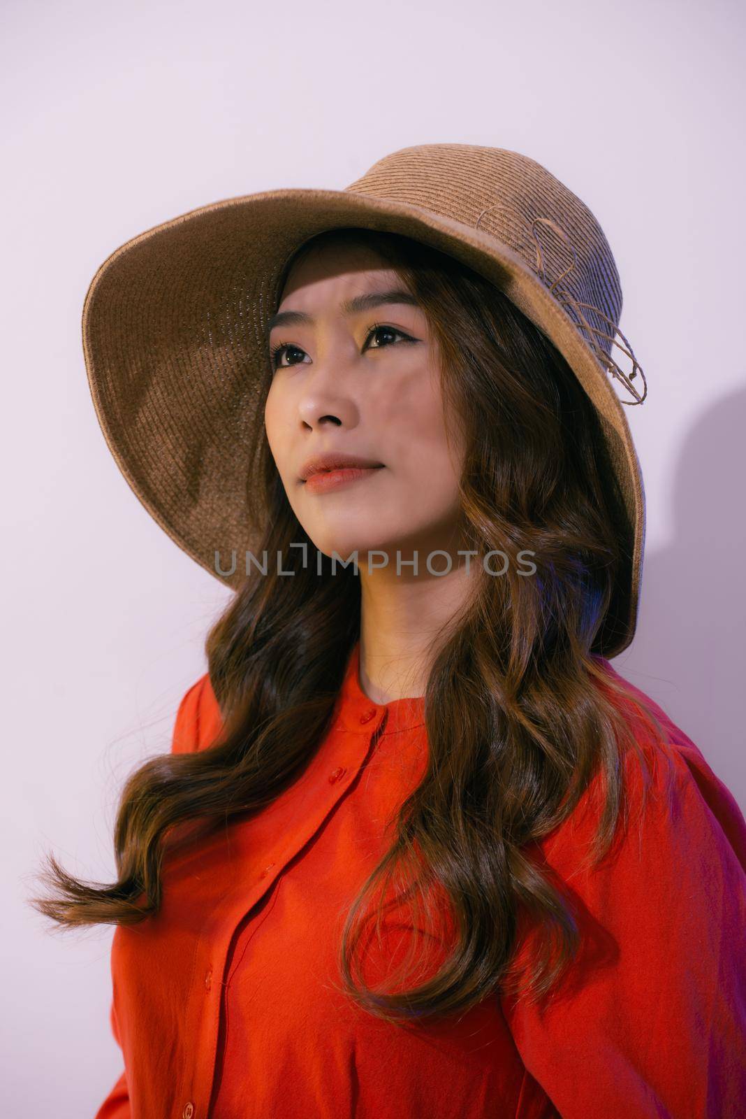 Portrait of young beautiful woman in hat isolated on pink by makidotvn