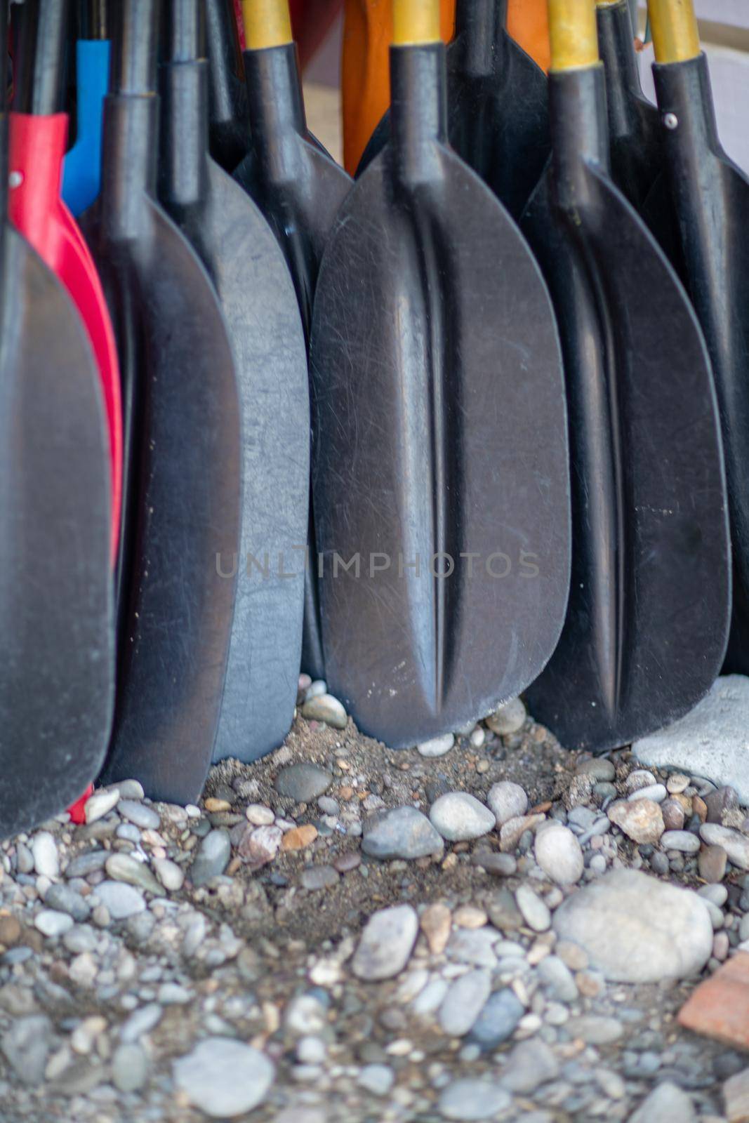 Colorful paddle kayaks stand near the wall. Active recreation concept. by Matiunina