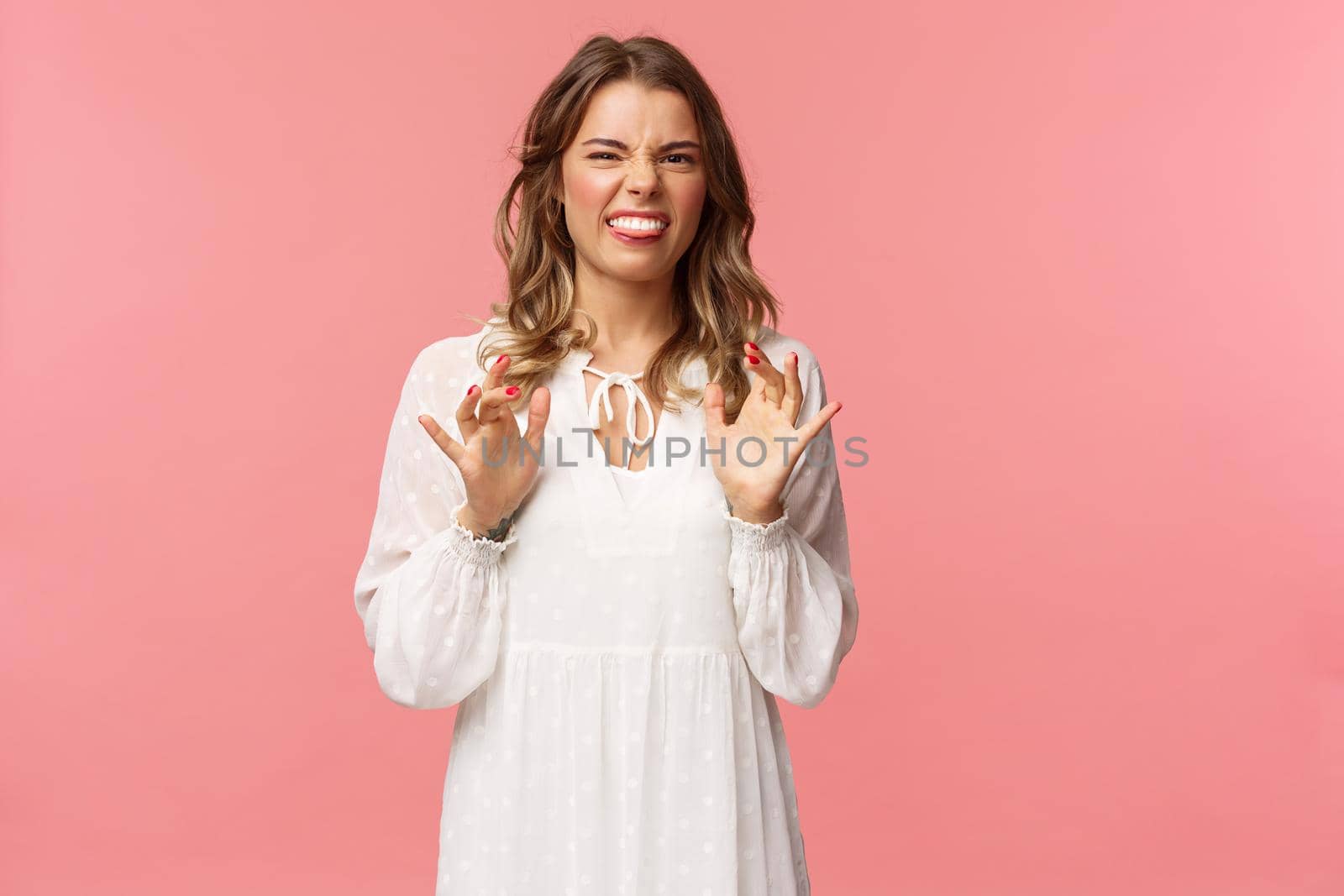 Portrait of girl cringe as telling friend disgusting awful story of her date with guy, show tongue grimacing and press hands to body as feeling discomfort and aversion, stand pink background by Benzoix