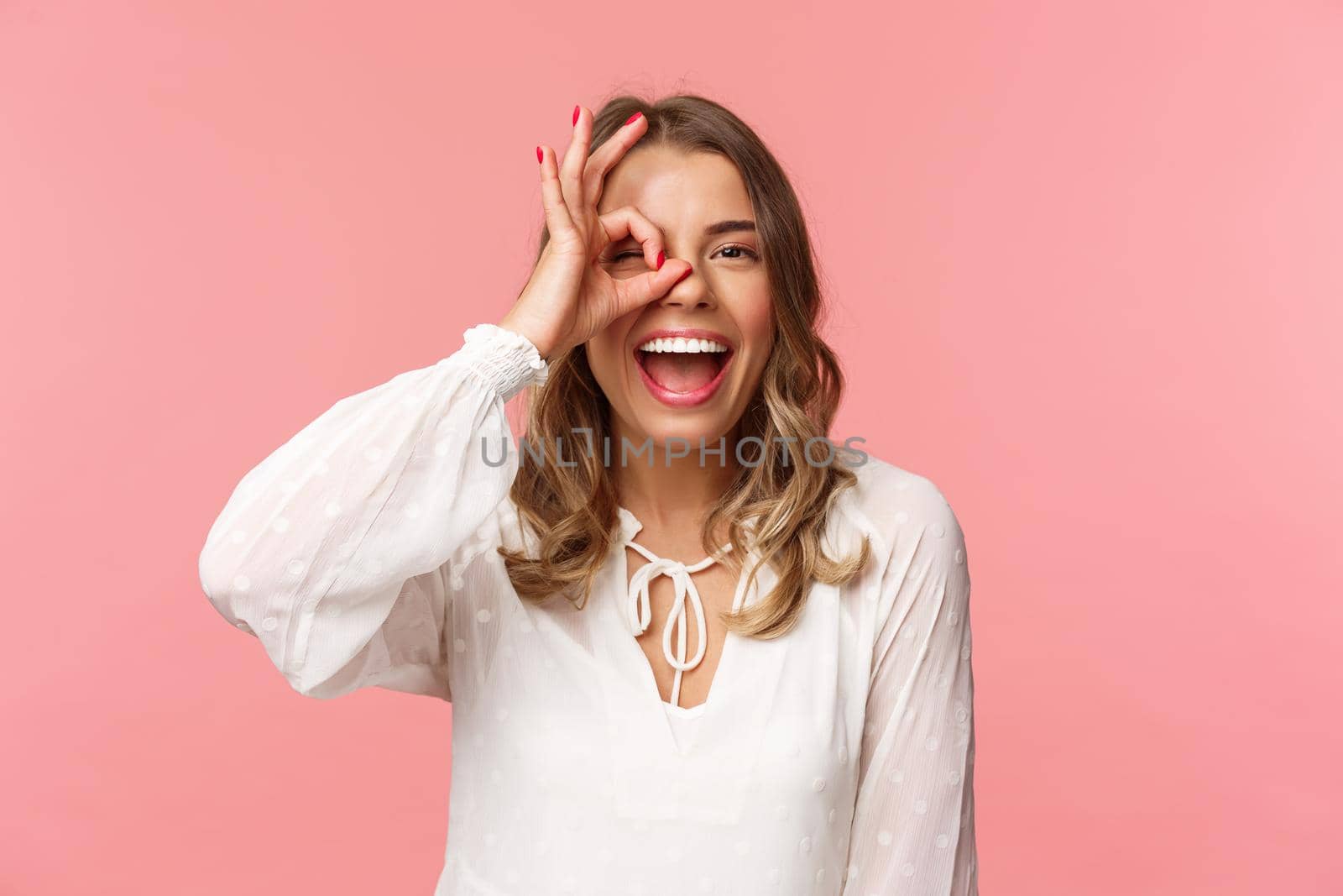 Close-up portrait of perfect good-looking blond girl in white dress, looking through okay sign and smiling, guarantee excellent quality, approve or like something, standing pink background by Benzoix