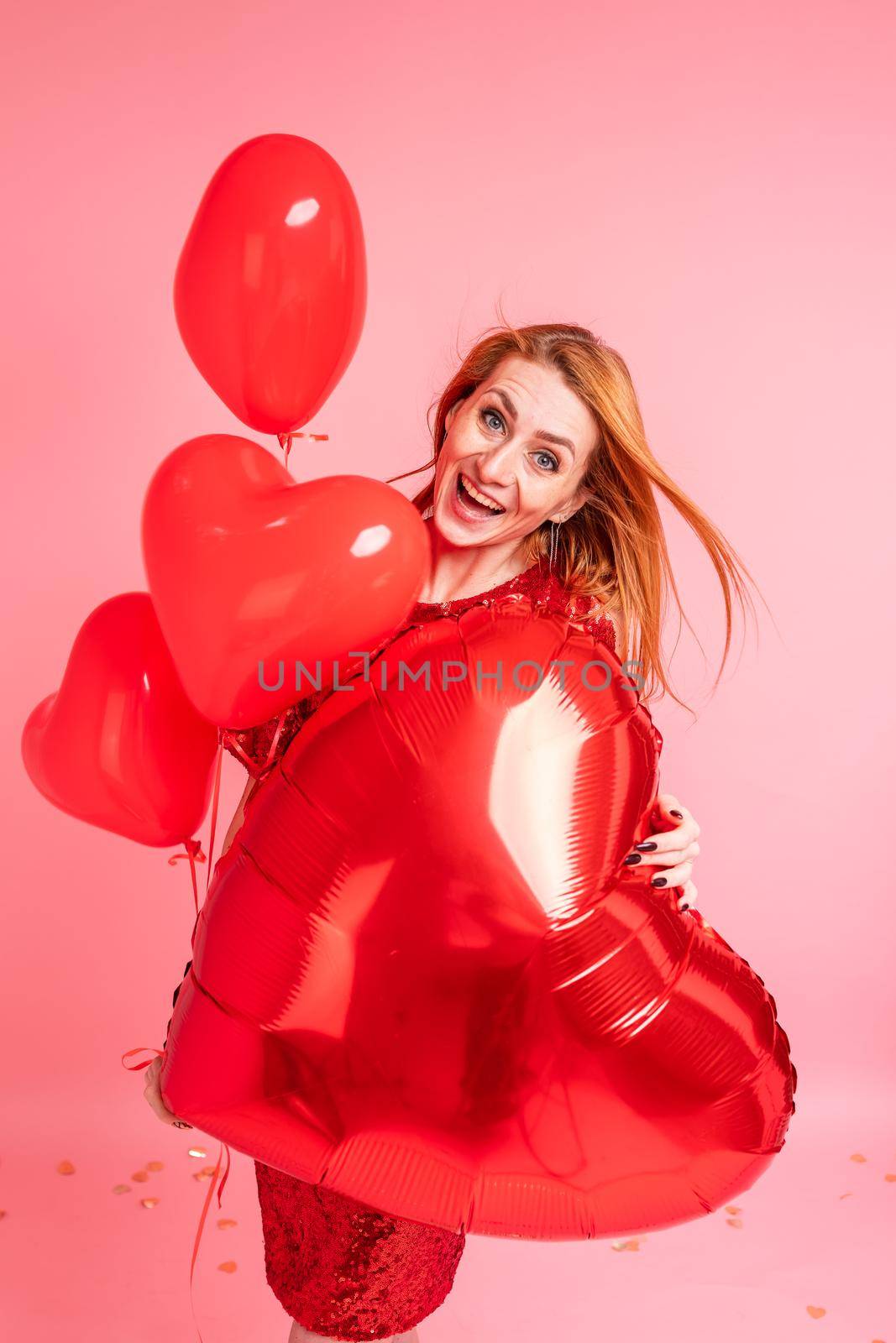 Beautiful redhead girl with red heart baloon posing. Happy Valentine's Day concept by Len44ik