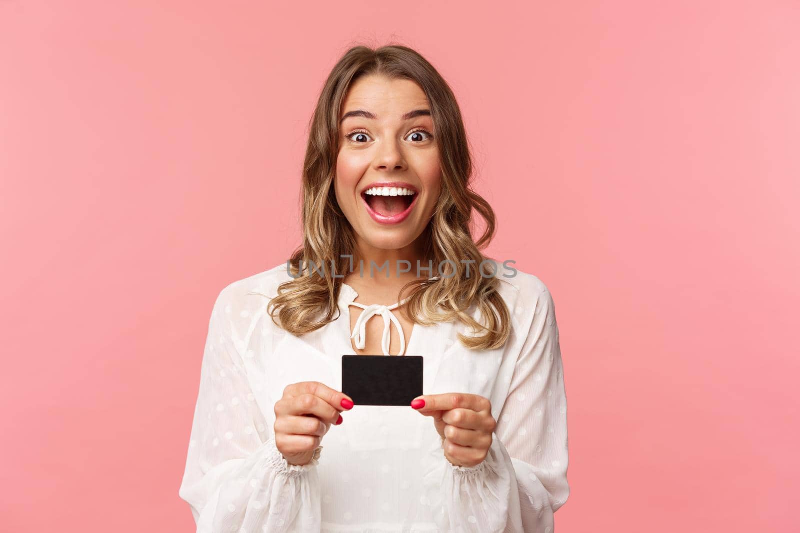 Close-up portrait of excited and happy good-looking blond female recommend bank, smiling amazed, holding credit card, paying for purchase, shopaholic in store feel upbeat by Benzoix