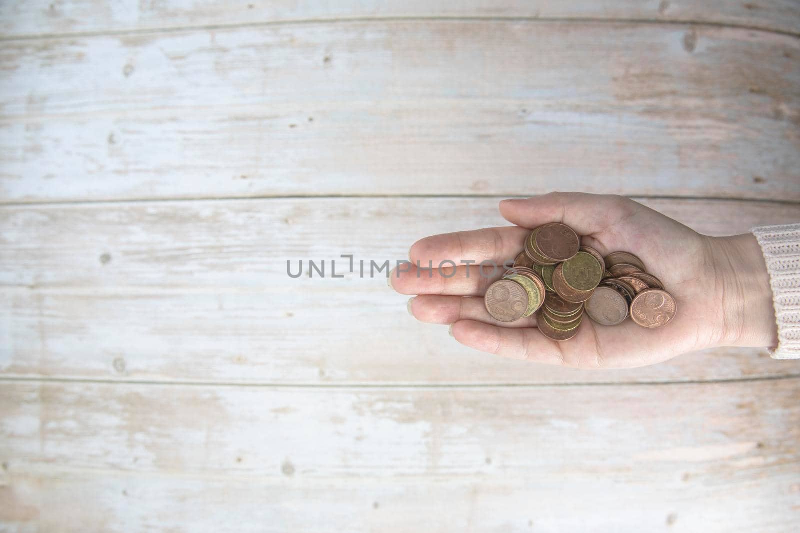 Hands holding pile of money euro coins in hand on wood background. Donation, saving, fundraising charity, family finance plan concept, financial crisis concept. Top view. copy space space for text