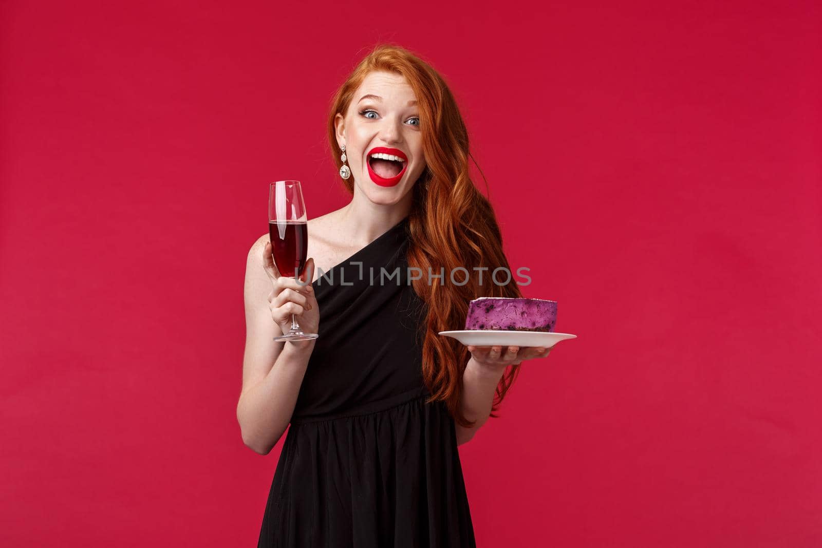 Portrait of gorgeous festive and excited woman celebrating birthday, feel amused and happy, holding glass champagne and b-day cake, having fun, wear black elegant dress over red background by Benzoix