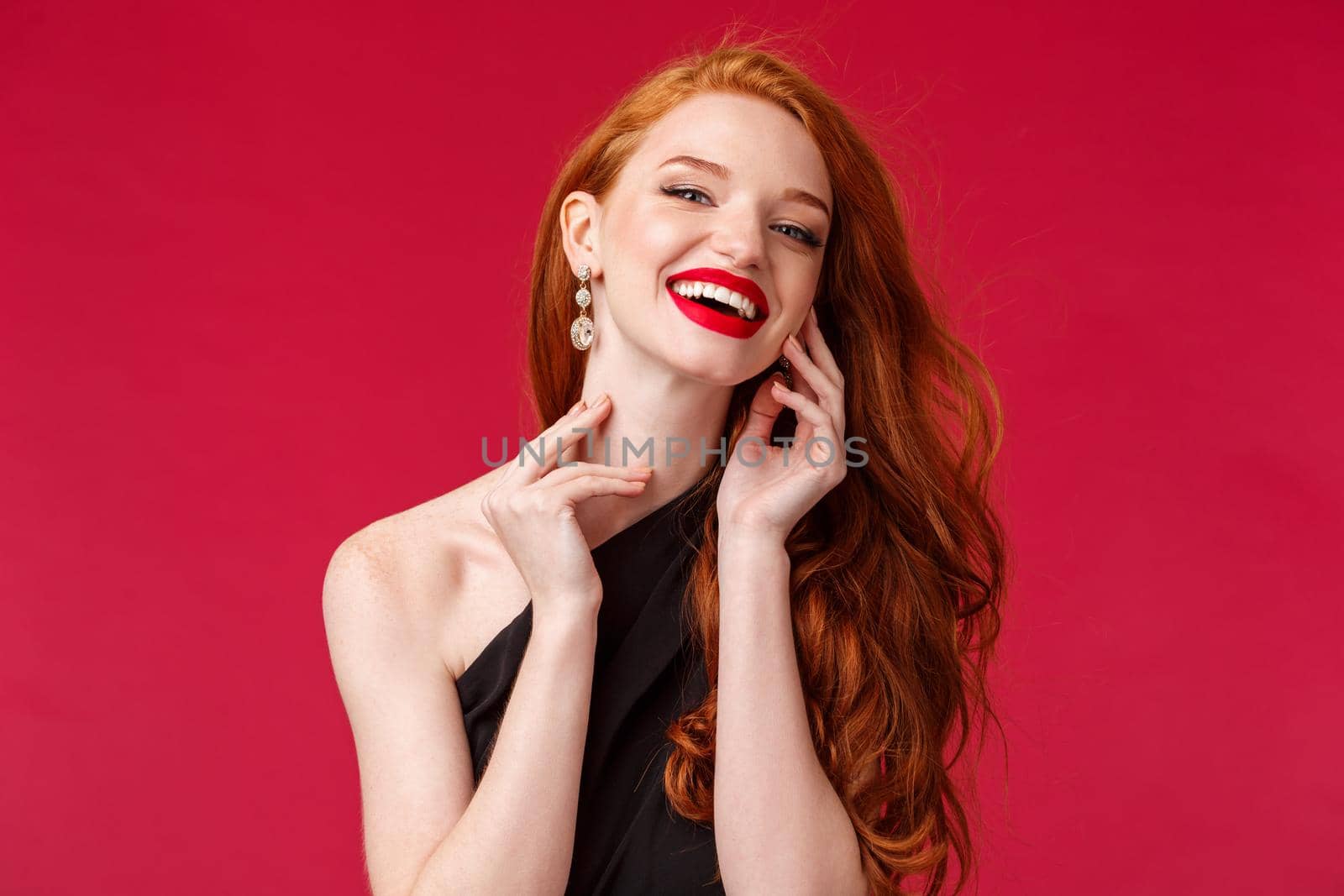 Makeup, beauty and women concept. Close-up portrait of feminine gorgeous young woman with long curly ginger hair, laughing silly and delighted, touching gently neck look camera flirting.
