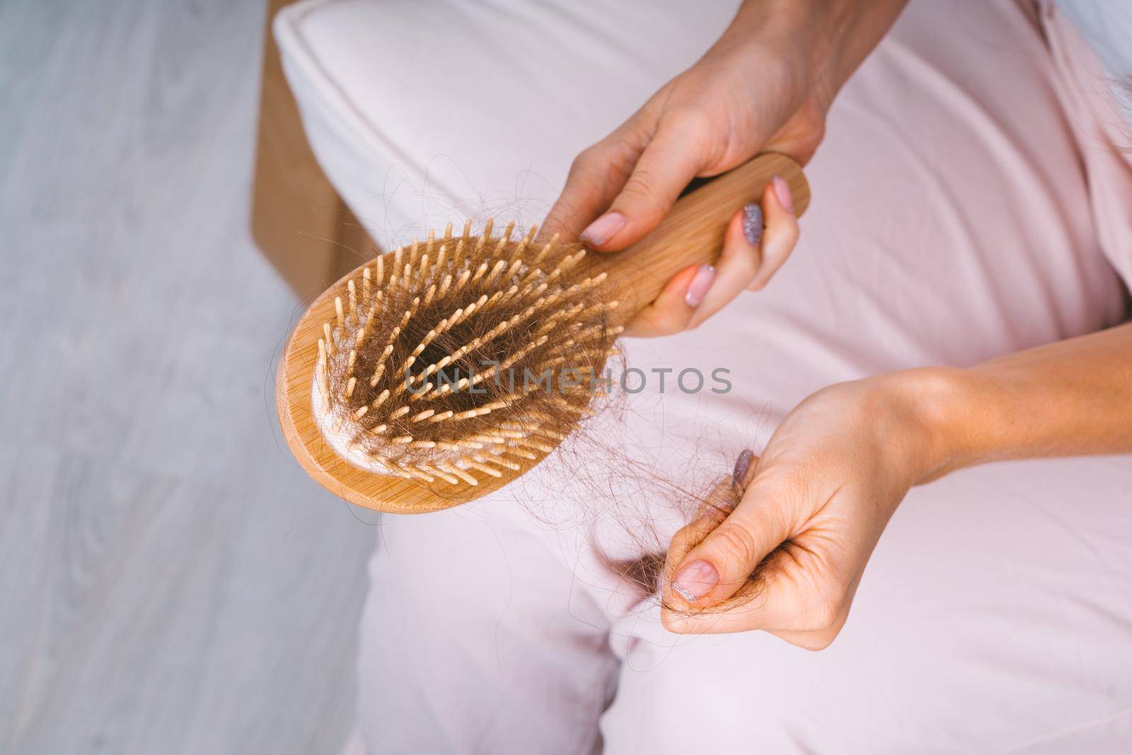 Woman taking her hair from hairbrush. Hair loss problem. Bad hair falling out. High quality photo