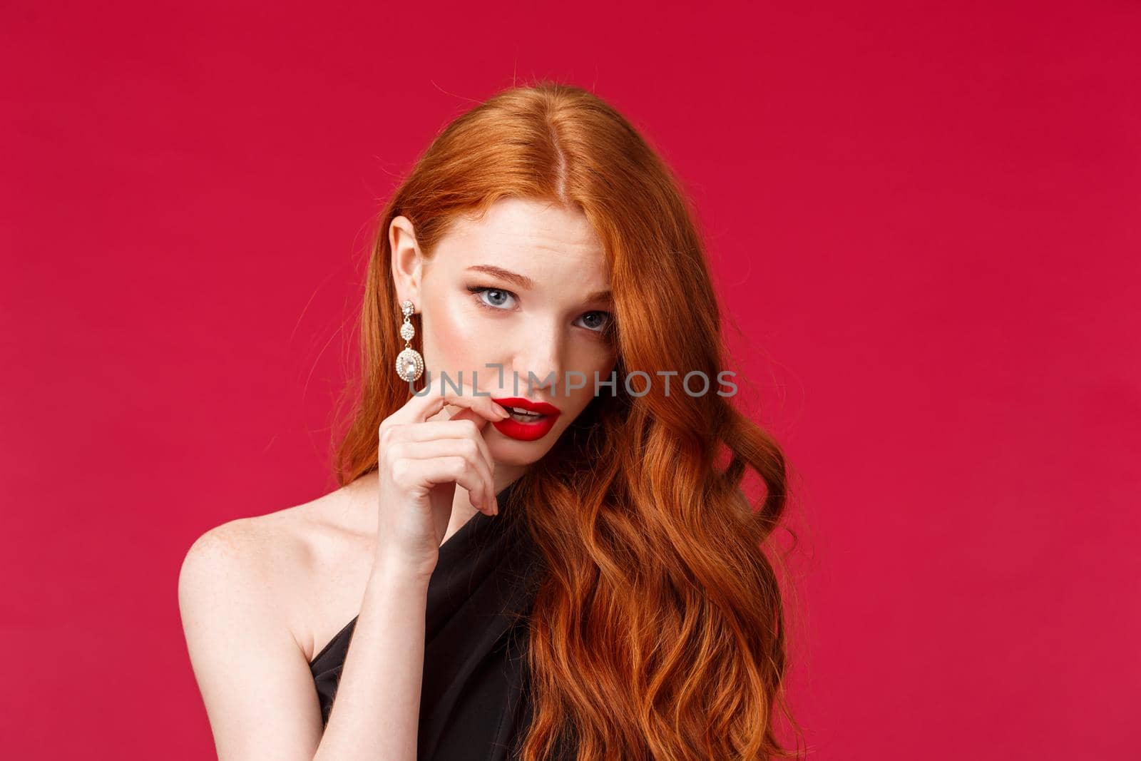 Close-up portrait of silly pretty feminine redhead woman with earrings, red lipstick and black dress, look from under forehead flirty, seducing someone acting clueless and dumb, red background by Benzoix