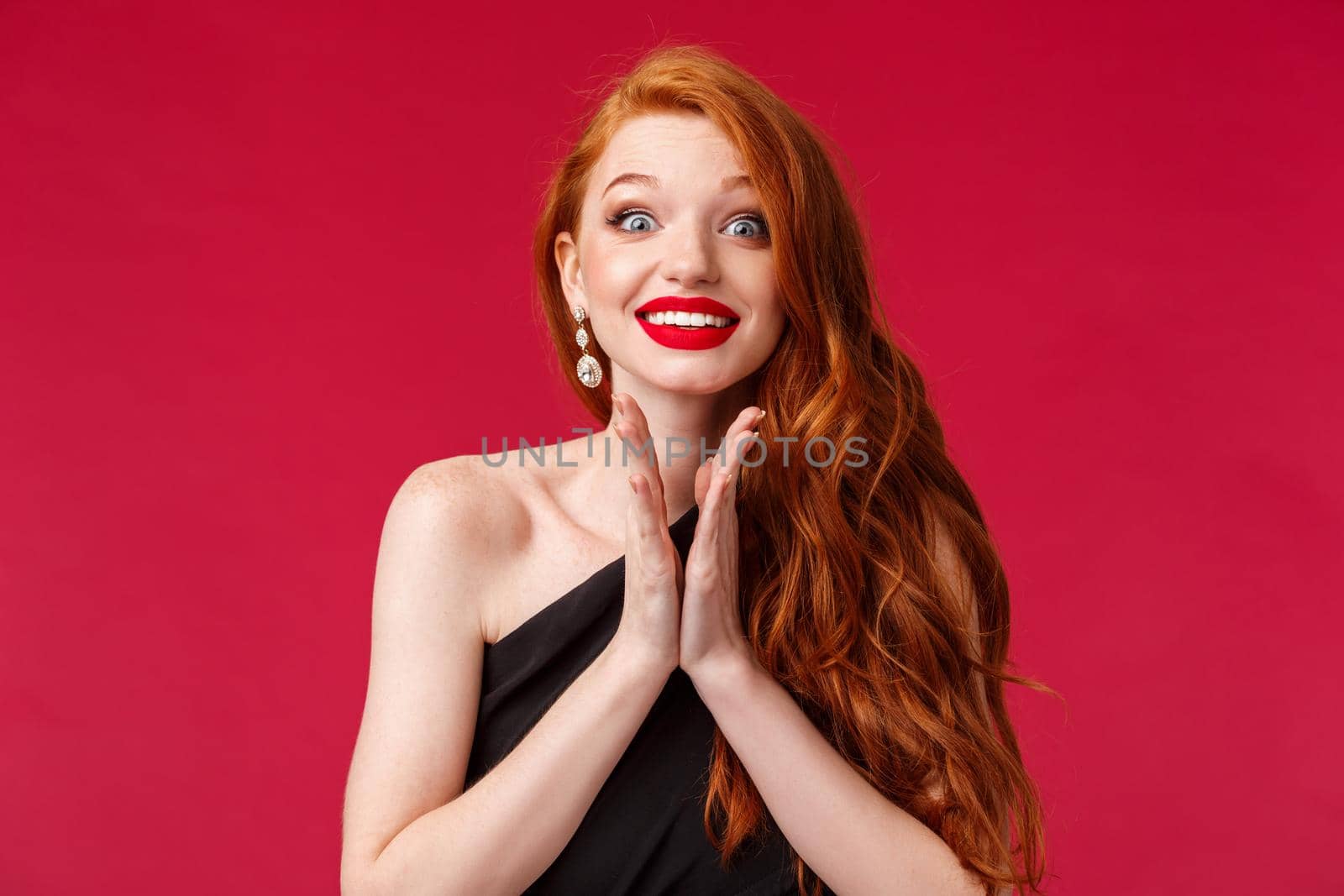 Close-up portrait of excited and eager young gorgeous redhead woman clap hands anticipating performance, smiling hopeful, awaiting for artist come on stage cant wait to hear him, red background.