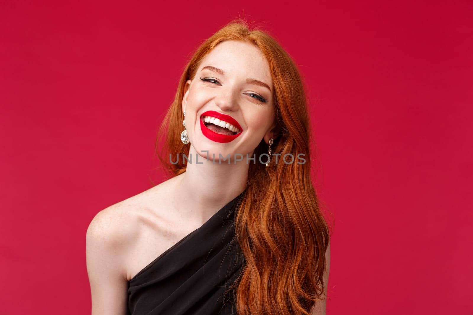 Romance, elegance, beauty and women concept. Close-up portrait of happy, cheerful redhead woman in luxurious black dress, red lipstick, enjoying party or date, laughing beaming smile.