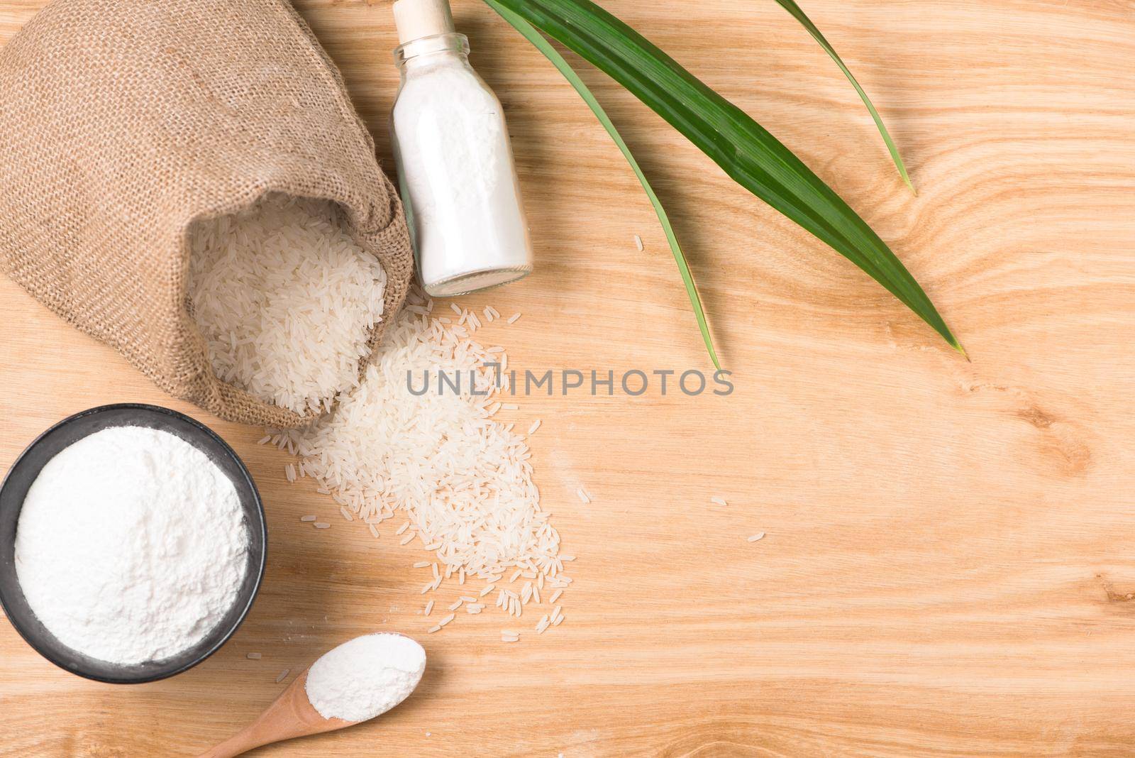 rice flour in a wooden bowl, rice on the wooden background. gluten-free