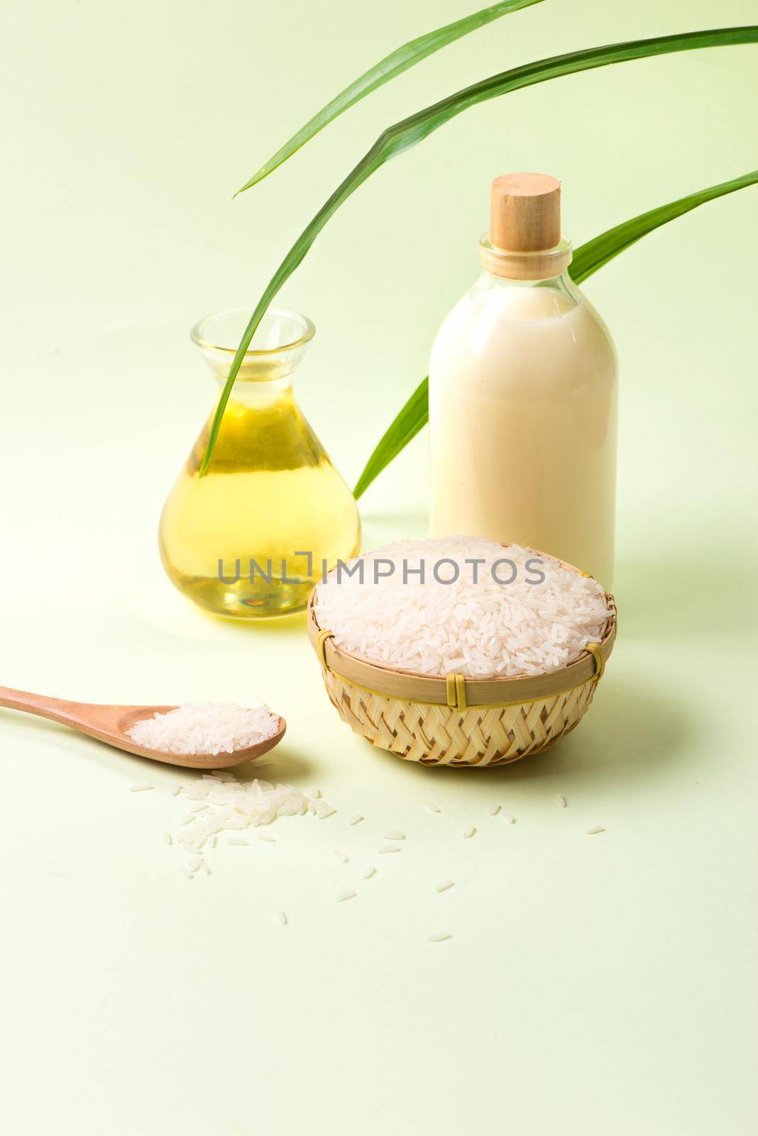 Rice bran oil in a glass and jar with uncooked jasmine rice 