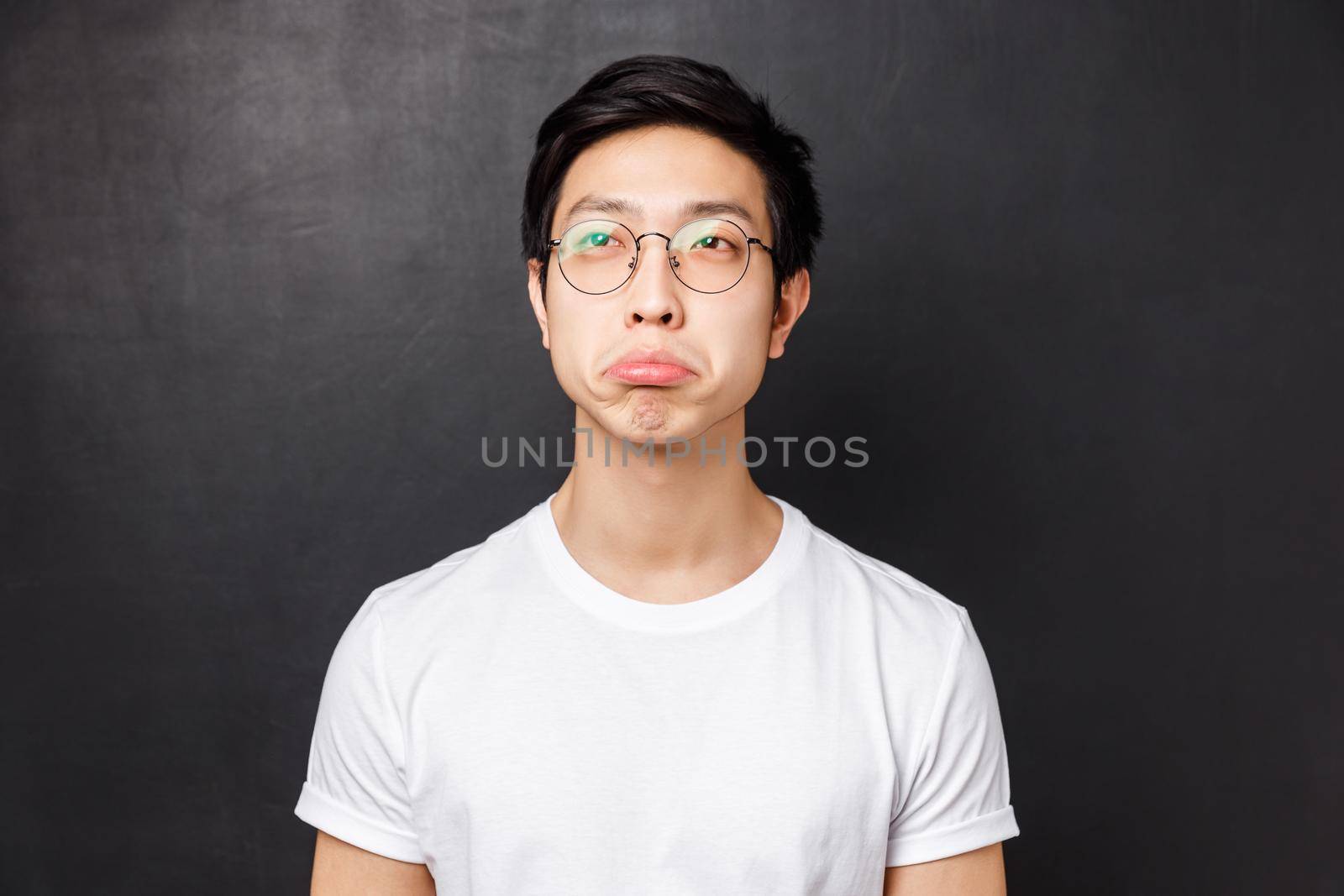 Close-up portrait of impressed asian young man in white t-shirt and glasses, look upper left corner with approval say not bad, squinting and nod acceptingly, standing black background by Benzoix