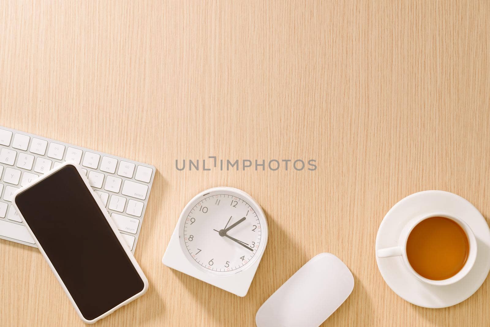 Modern white office desk with keyboard, mouse, clock, cellphone, pen and cup of coffee.Top view with copy paste. Business and strategy concept mockup.