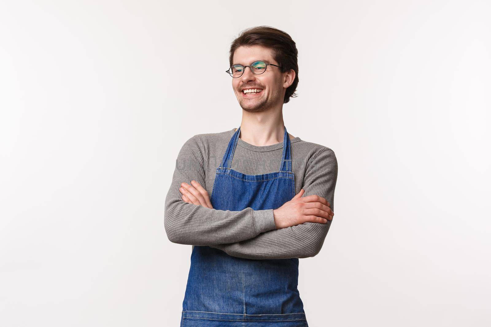 Carefree smiling young outgoing male bartender laughing with coworker standing in apron with hands crossed chest, look away delighted, manage own small business cafe, stand white background.