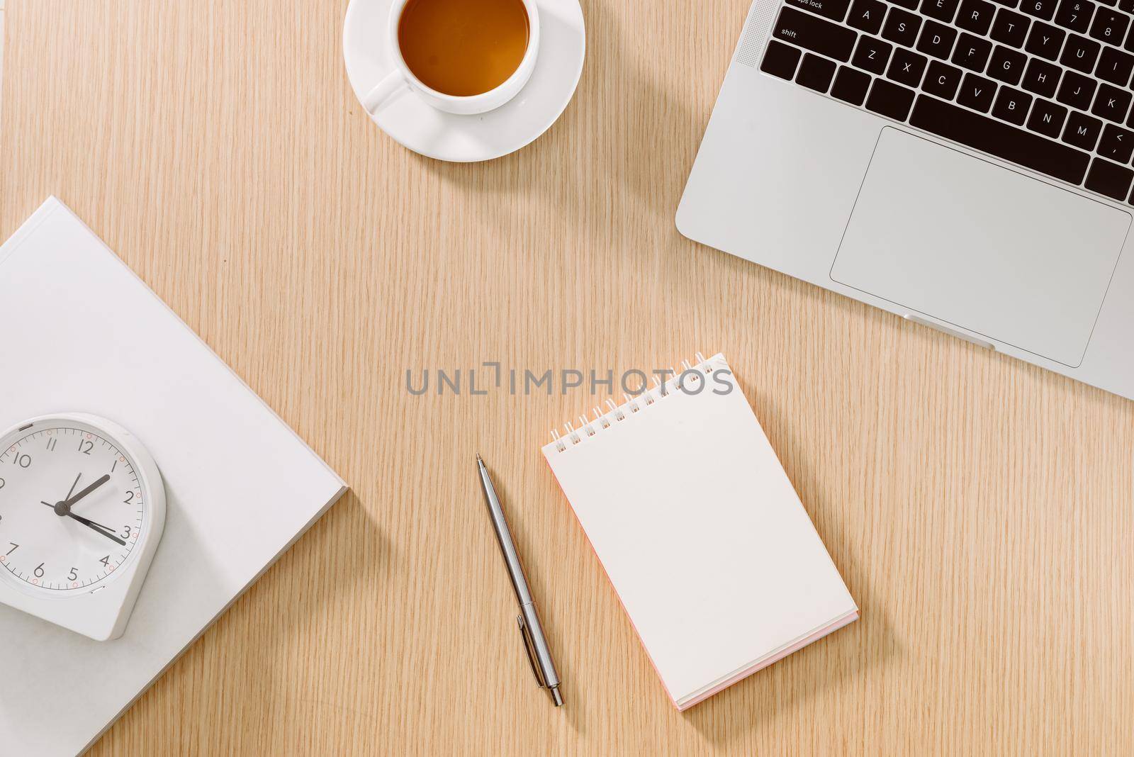 Office desk table with laptop, smart phone, cup of coffee, pen, pencil and notebook. Office supplies and gadgets on desk table. Working desk table concept.