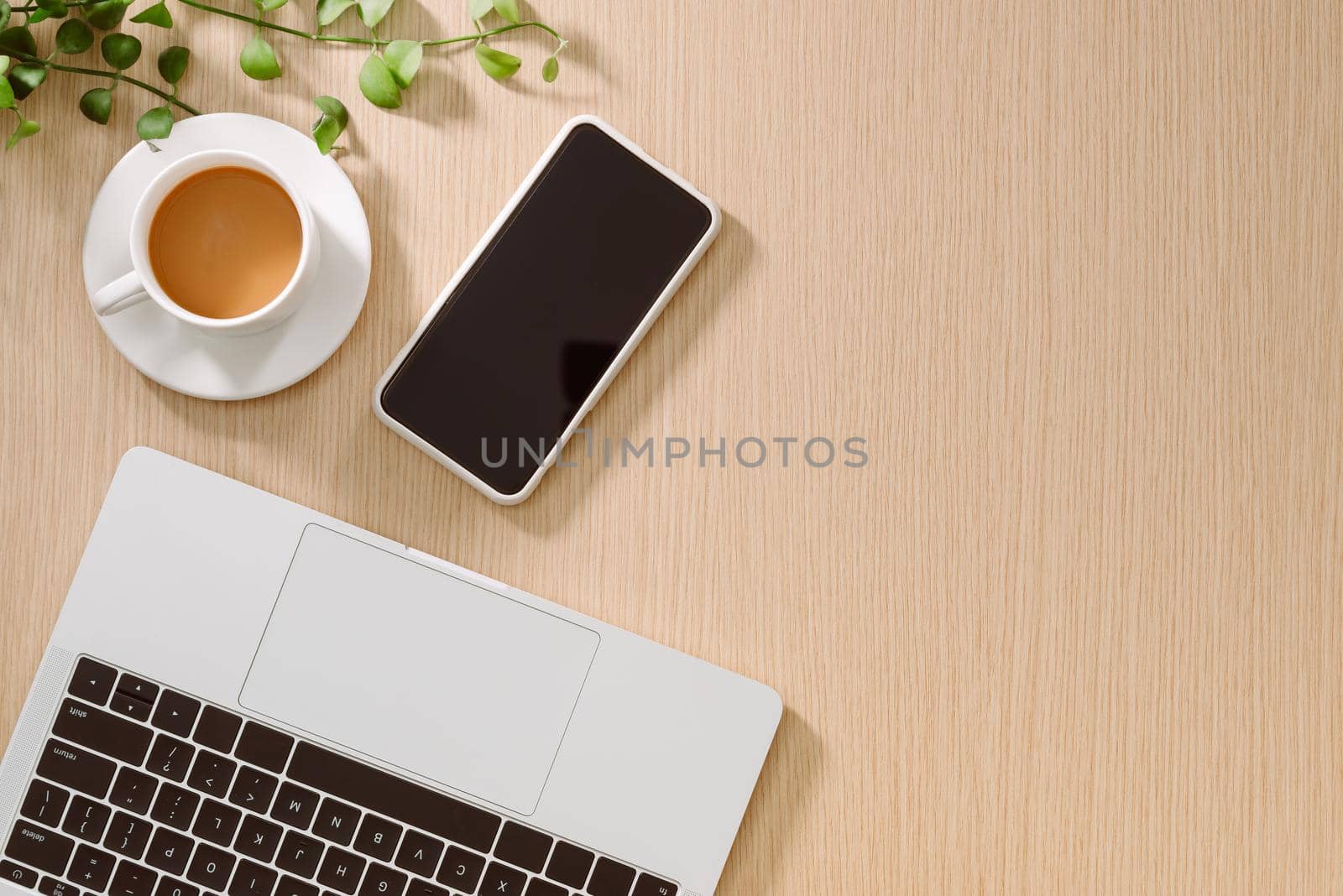 Trendy feminine home office workspace. White office desk. Laptop, coffee cup and phone, notebook, pencil. Flat lay, top view, copy space