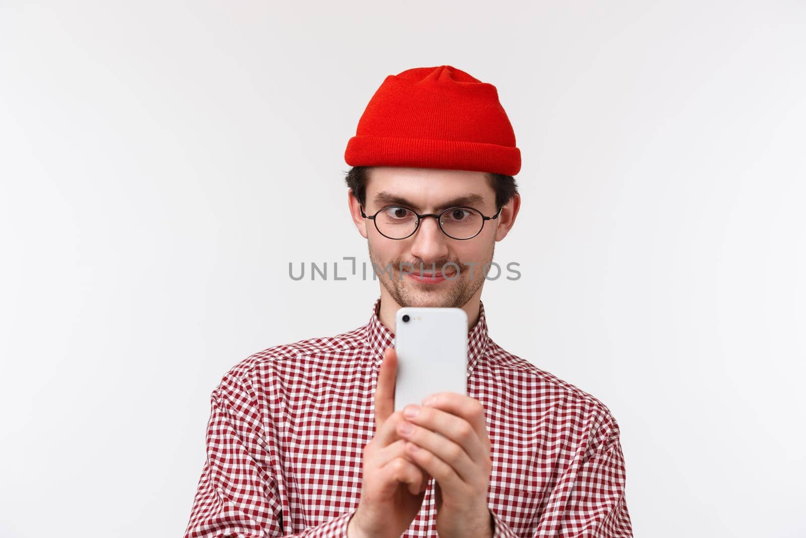 Technology and people concept. Close-up portrait excited handsome bearded man in red beanie and glasses record video on smartphone, taking picture of something cool, hold mobile phone.
