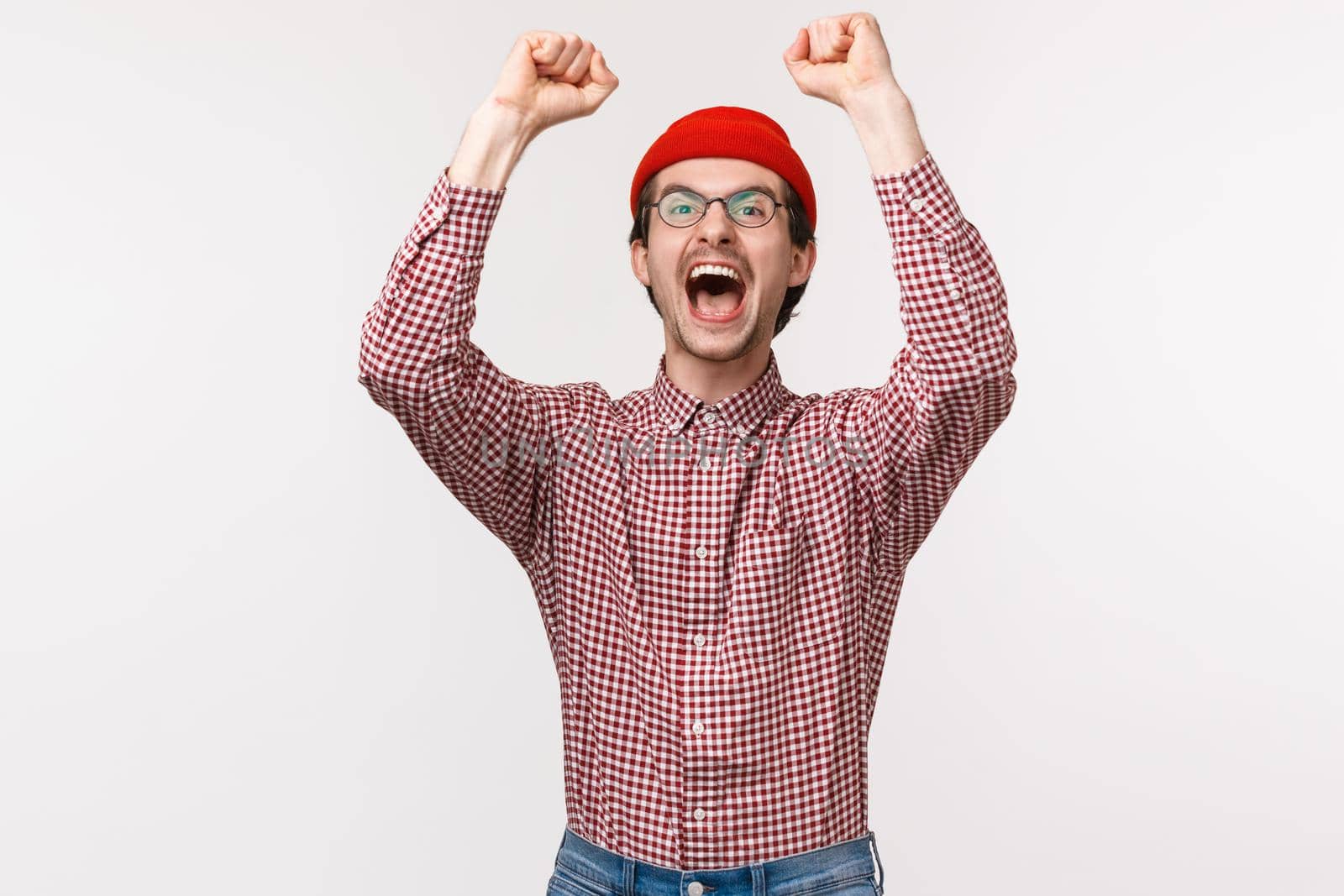 Waist-up portrait of excited and thrilled happy relieved man winning prize, receive award scream from joy and delight, raise hands up in victory, triumphing, celebrating great news.