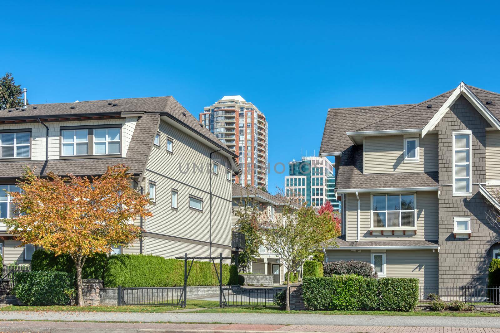Residential apartment buildings on blue sky background. Buildings with concrete pathway in front
