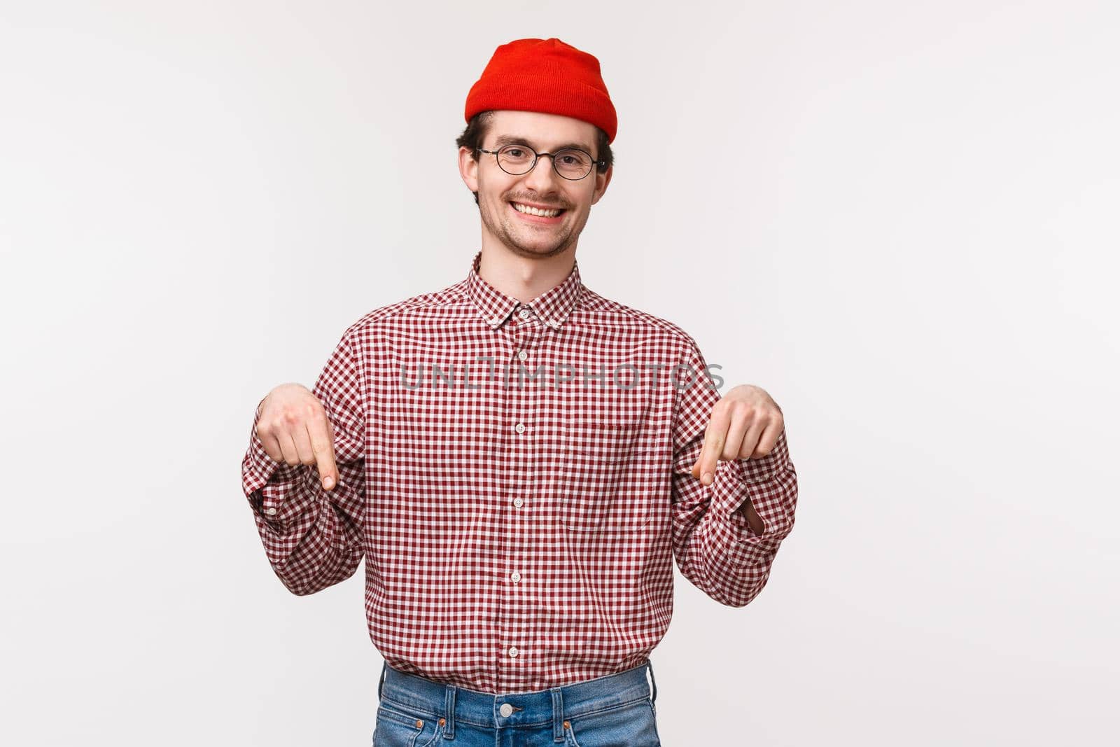 Waist-up portrait friendly-looking smiling happy and satisfied young male customer in red beanie and glasses, pointing fingers down to introduce new store or application, download banner by Benzoix