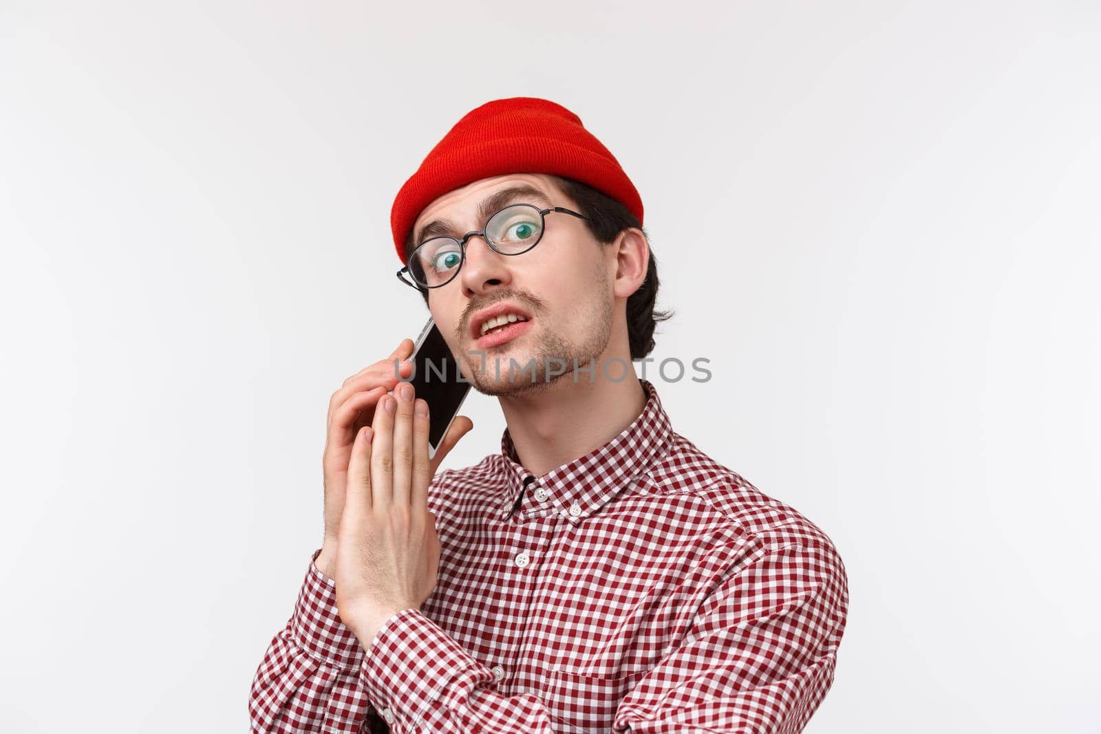 Portrait of busy guy talking on phone, asking hold on minute as have important conversation, calling friend on mobile, cover dynamic to tell wait sec, standing white background with smartphone.
