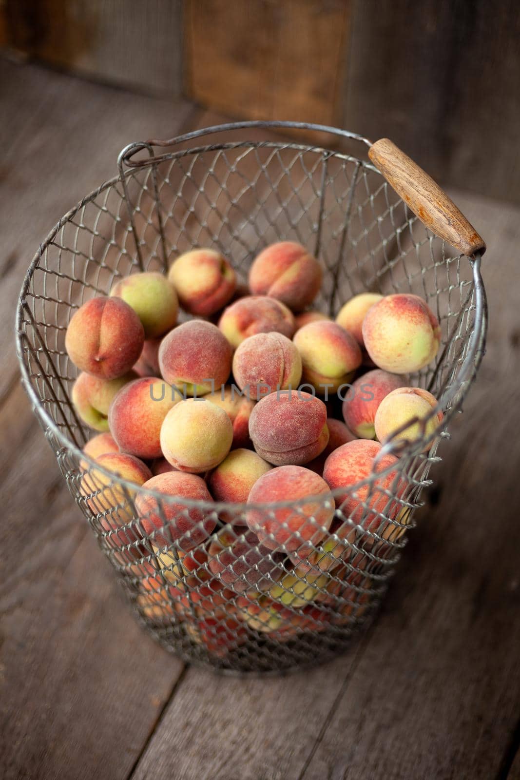 Fresh peaches fruits in basket on dark wooden rustic background, top view. Summer harvest of fruit. Still life. A group of ripe peach. Flat lay vegan food. Copy space by A_Gree