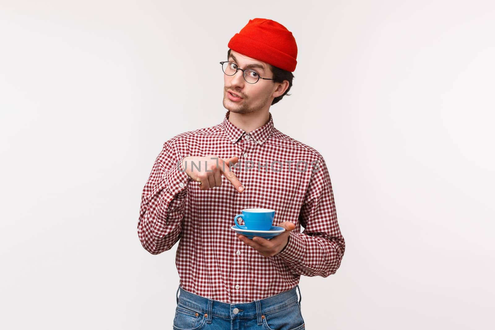 Want some. Friendly-looking funny young hipster bearded guy in red beanie and glasses, suggest coworker cup of coffee, pointing at his tea as asking for refill, standing white background by Benzoix