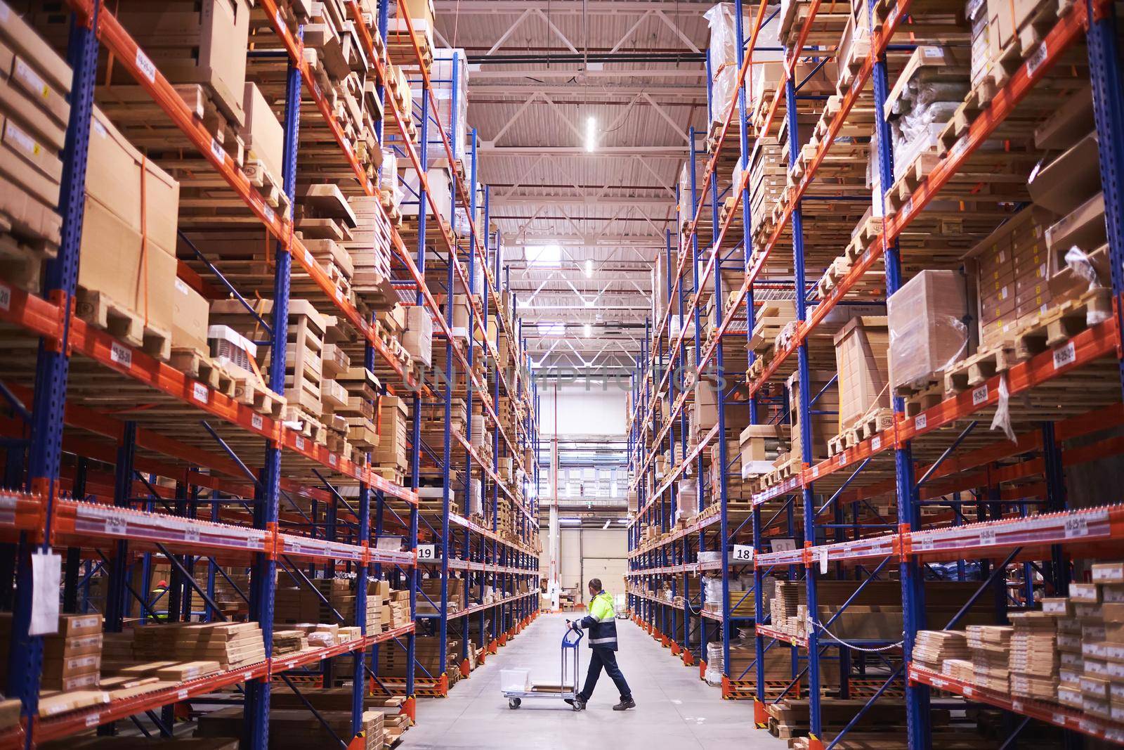 Male warehouse worker pulling a pallet truck