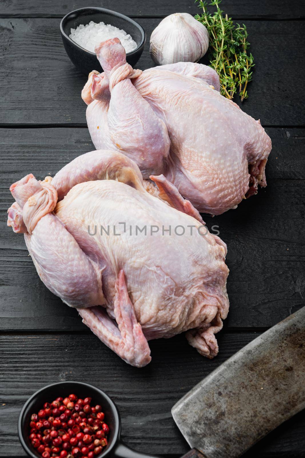 Fresh raw chicken meat with herbs spices, on black wooden table