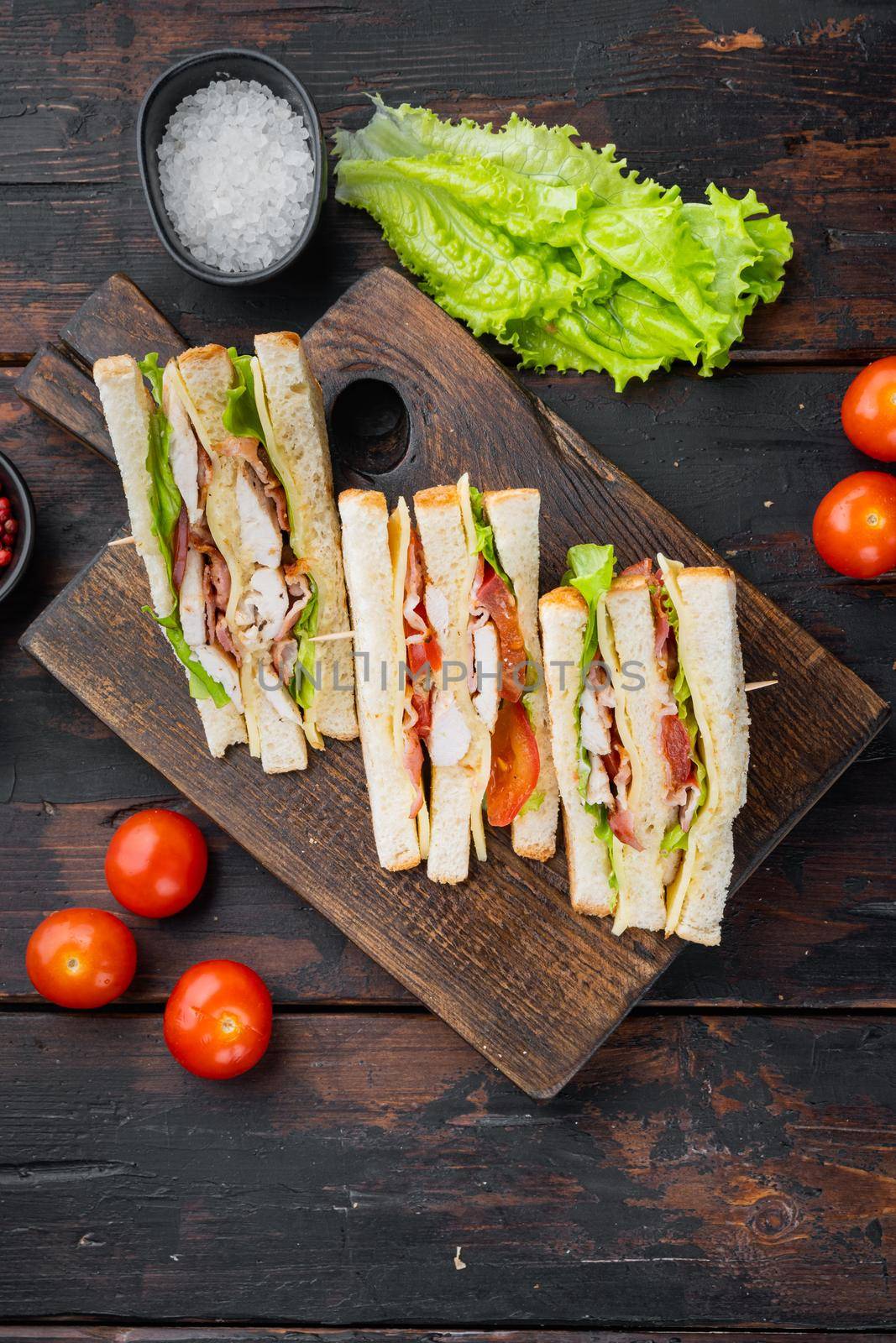 Homemade turkey club sandwich, on dark wooden background, top view