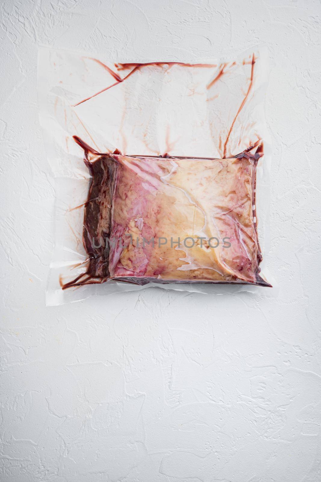 Top sirloin beef big cut in plastic pack, on white background, top view, with copy space for text