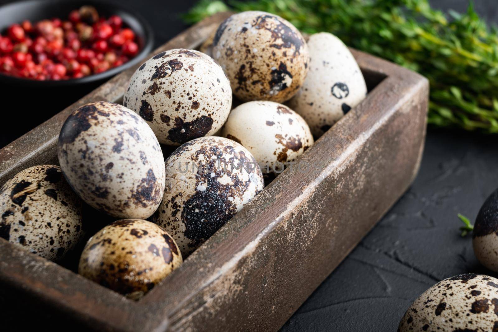 Quails eggs, on black textured background
