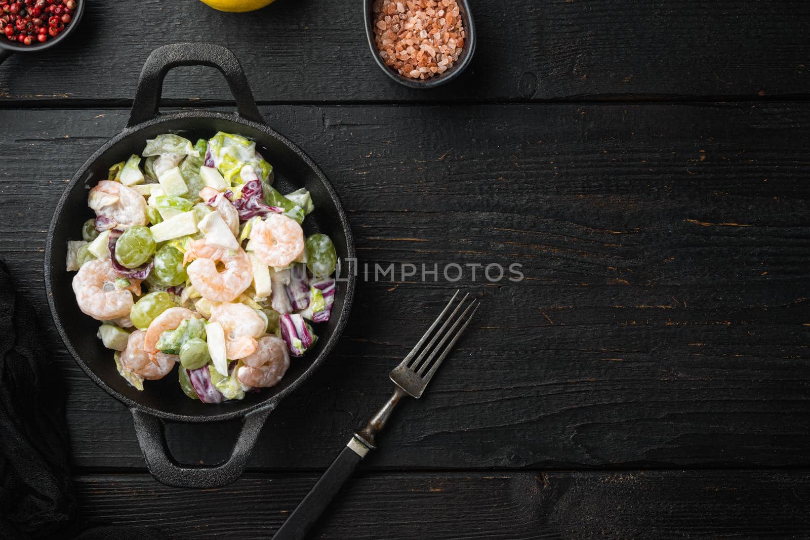 Healthy food concept, Diet salad plate. Fresh seafood salad with prawns or shrimp set , with sauce apple and grape, on black wooden table, top view flat lay, with copy space for text