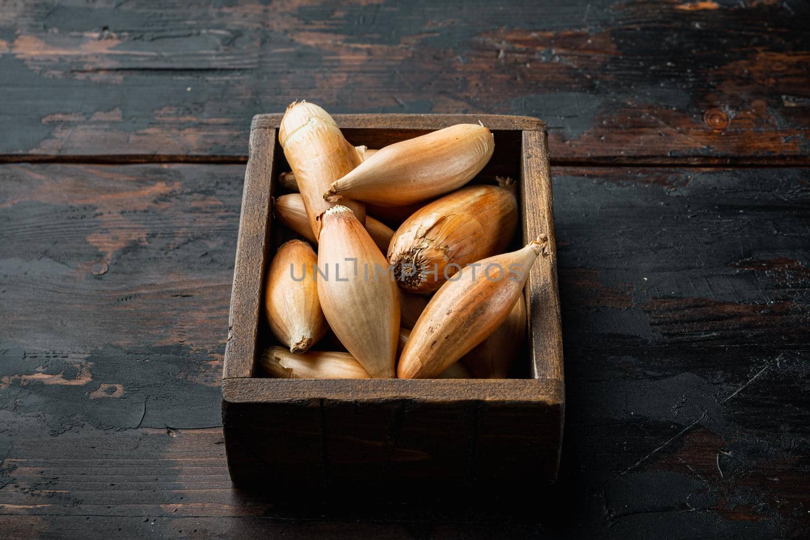 Raw whole baby shallot onion, on old wooden table
