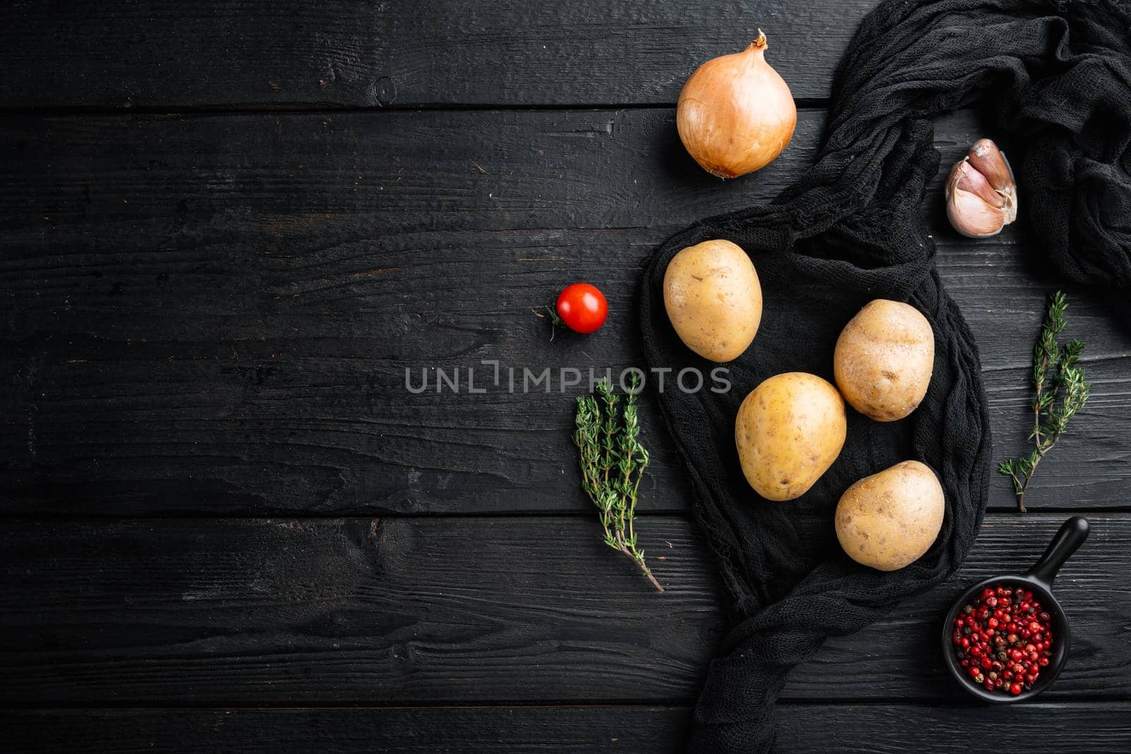 Fresh Pile of potatoes set, on black wooden table background, top view flat lay , with space for text copyspace