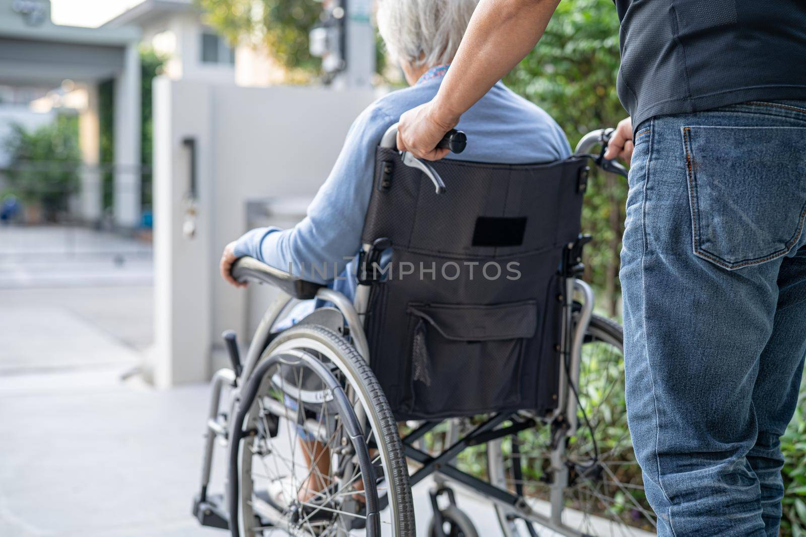 Caregiver help and care Asian senior or elderly old lady woman patient sitting on wheelchair at nursing hospital ward, healthy strong medical concept by pamai