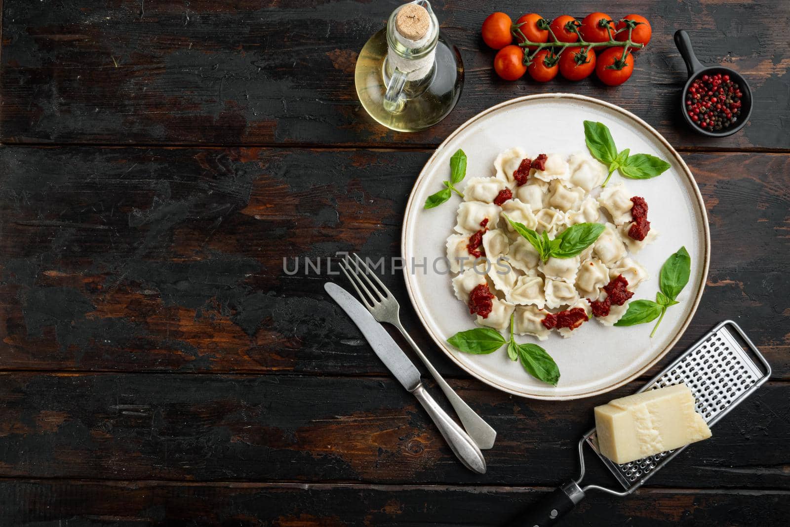 Ravioli pasta with mushroom cream sauce and cheese - Italian food style set with basil parmesan and tomatoe on white plate on old dark wooden table background, top view flat lay , with copyspace and space for text