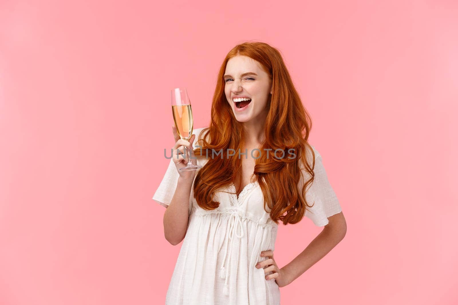 Wild and free, joyful redhead girl feeling awesome and thrilled, celebrating, enjoying cool party, raising glass, saying cheers, look sassy and amused as drinking champagne, celebrating.