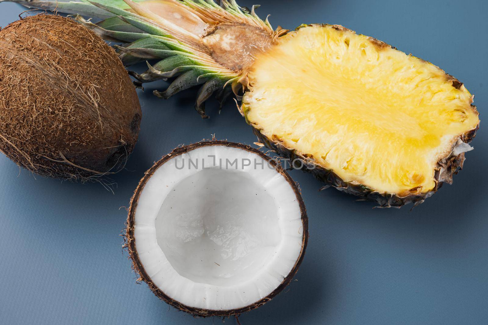 Fresh fruits, pineapple and Coconut set, on blue textured summer background, top view flat lay