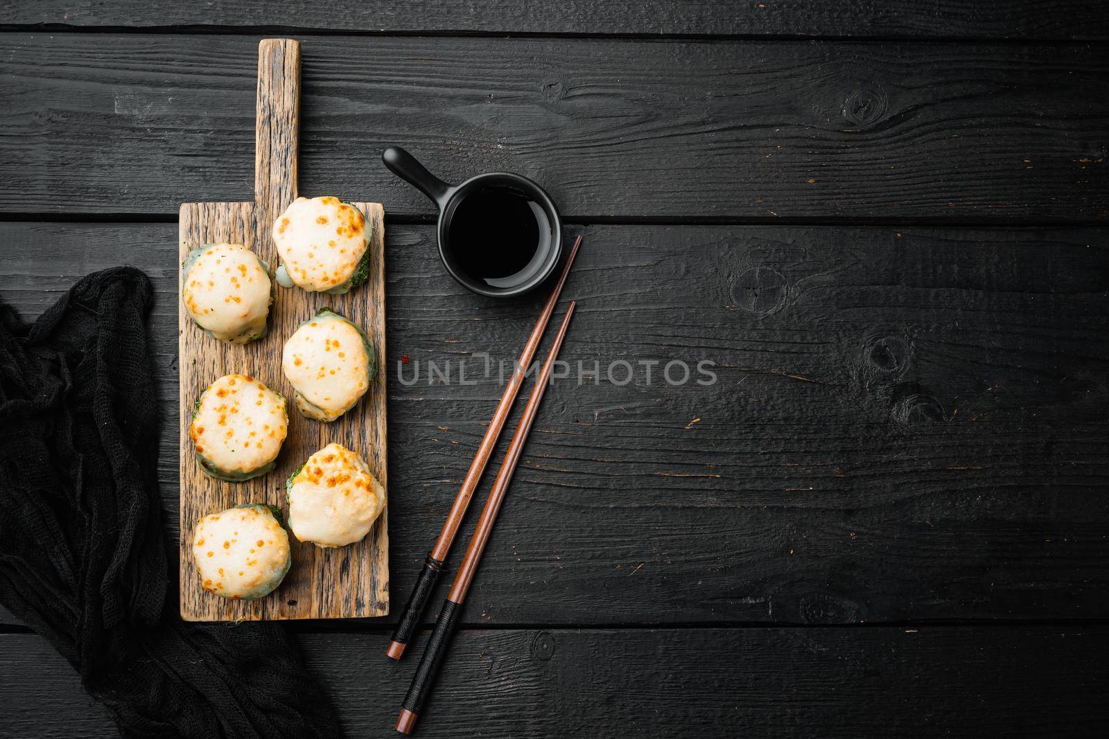 Japanese sushi rolls named Baked Ebi with wasabi and salmon fish set, on black wooden table background, top view flat lay , with copyspace and space for text