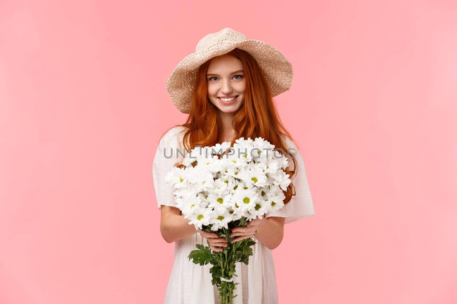 Its for you, congratulations. Alluring lovely young charismatic redhead girl giving bouquet of white flowers and smiling, congrats with birthday, express love and care, standing pink background.