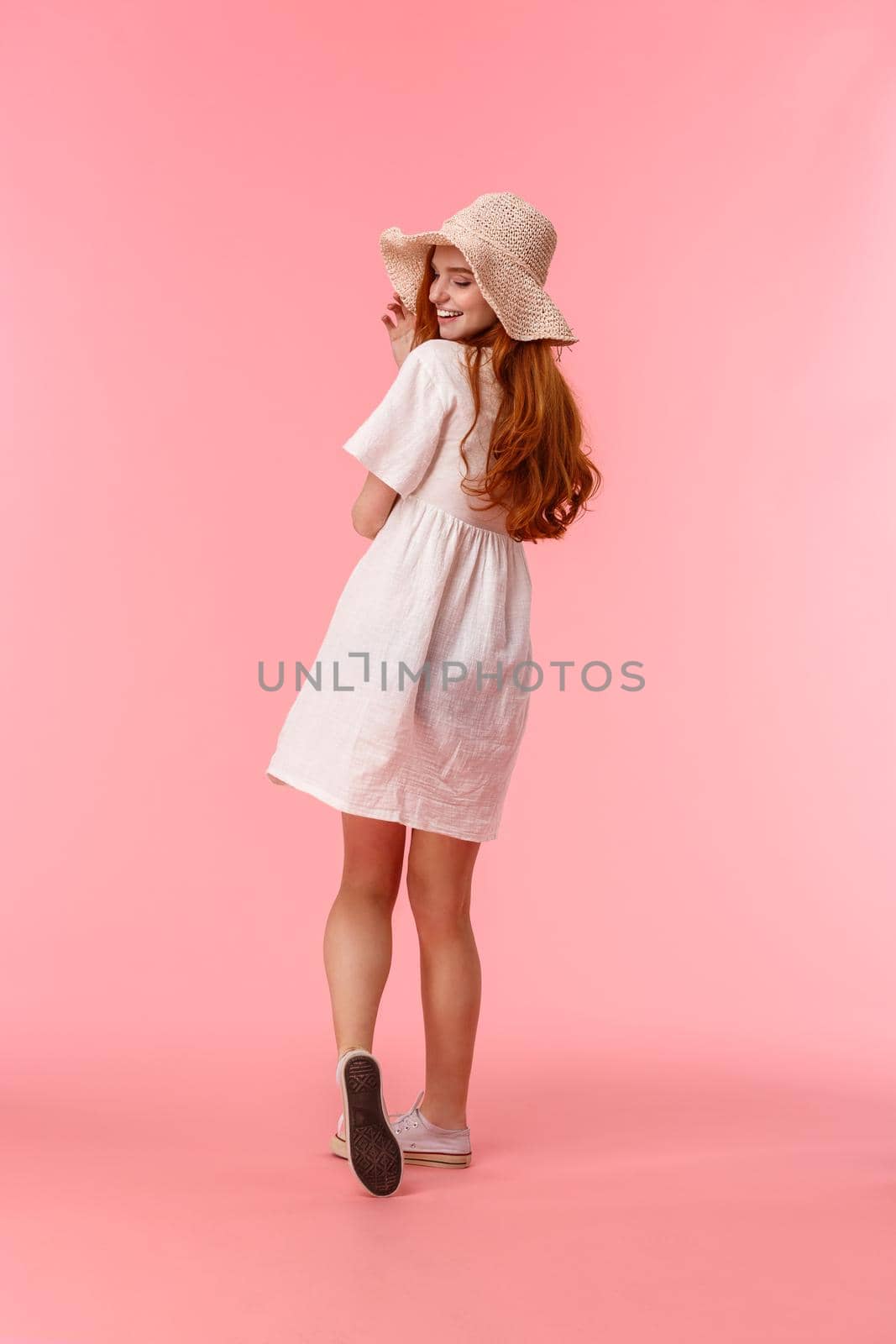 Full-length vertical shot upbeat, charismatic and cute, silly redhead female in white dress and summer straw hat, walking along beautiful park, enjoying vacation, turn back to smile camera coquettish by Benzoix