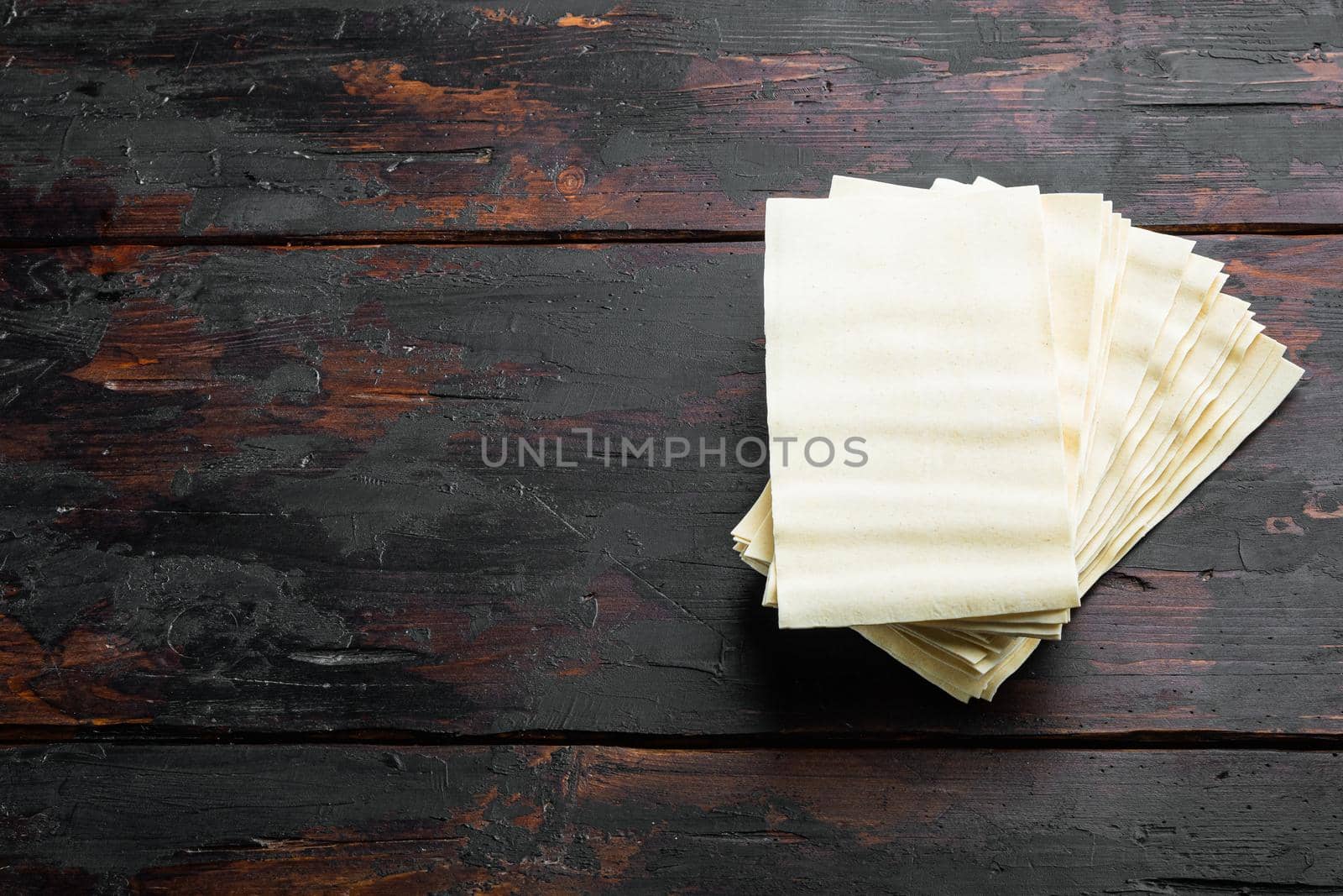 Lasagna dough sheets set, on old dark wooden table background, with copy space for text