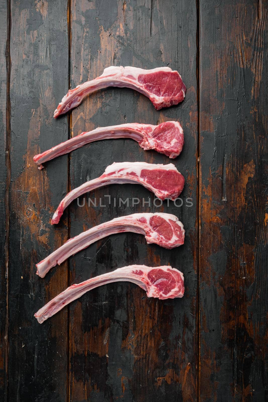 Raw fresh lamb loin chops, on old dark wooden table background, top view flat lay by Ilianesolenyi